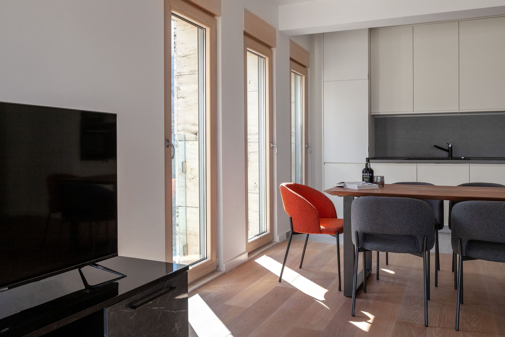 Modernes Wohnzimmer mit Küche in einer Wohnung, Kotor, Montenegro: helles Interieur, Holzboden und Essbereich.