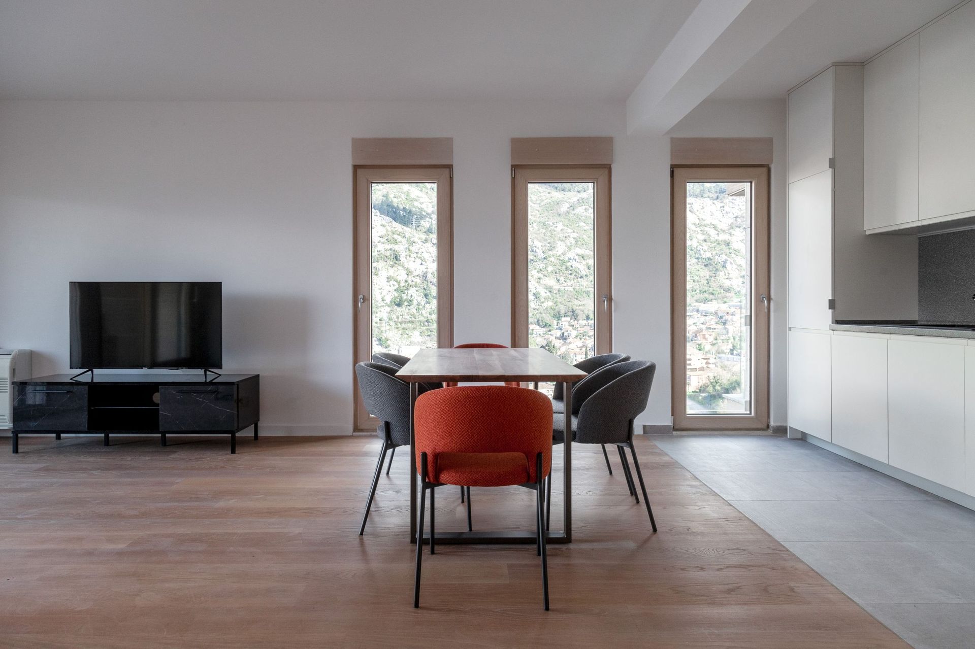 Modernes Wohnzimmer mit Essbereich in einer Wohnung, Kotor, Montenegro: Bergblick, stilvolle Möbel und helles Interieur.