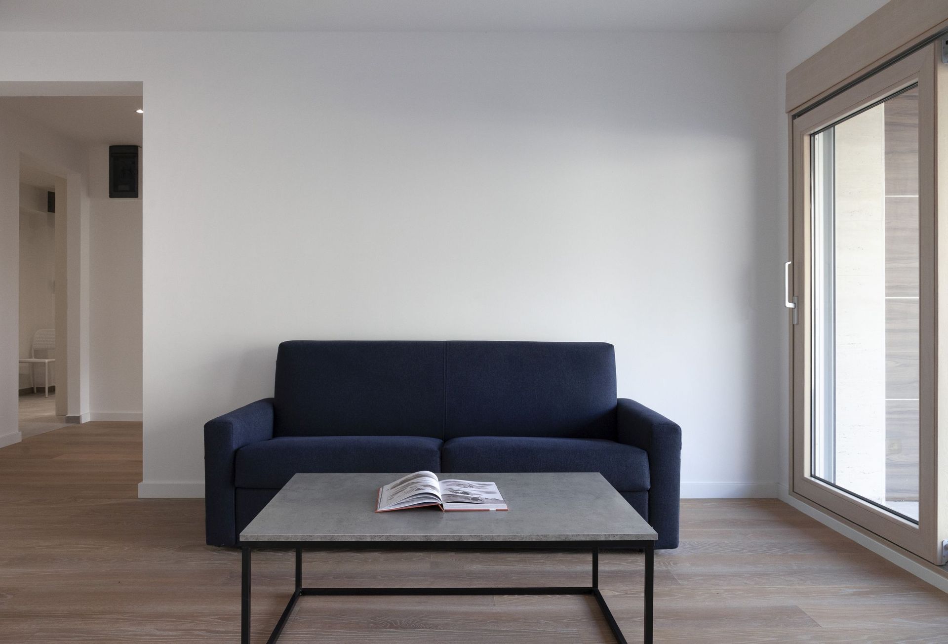 Modernes Wohnzimmer mit dunkelblauem Sofa und Couchtisch in einer Wohnung in Kotor, Montenegro.