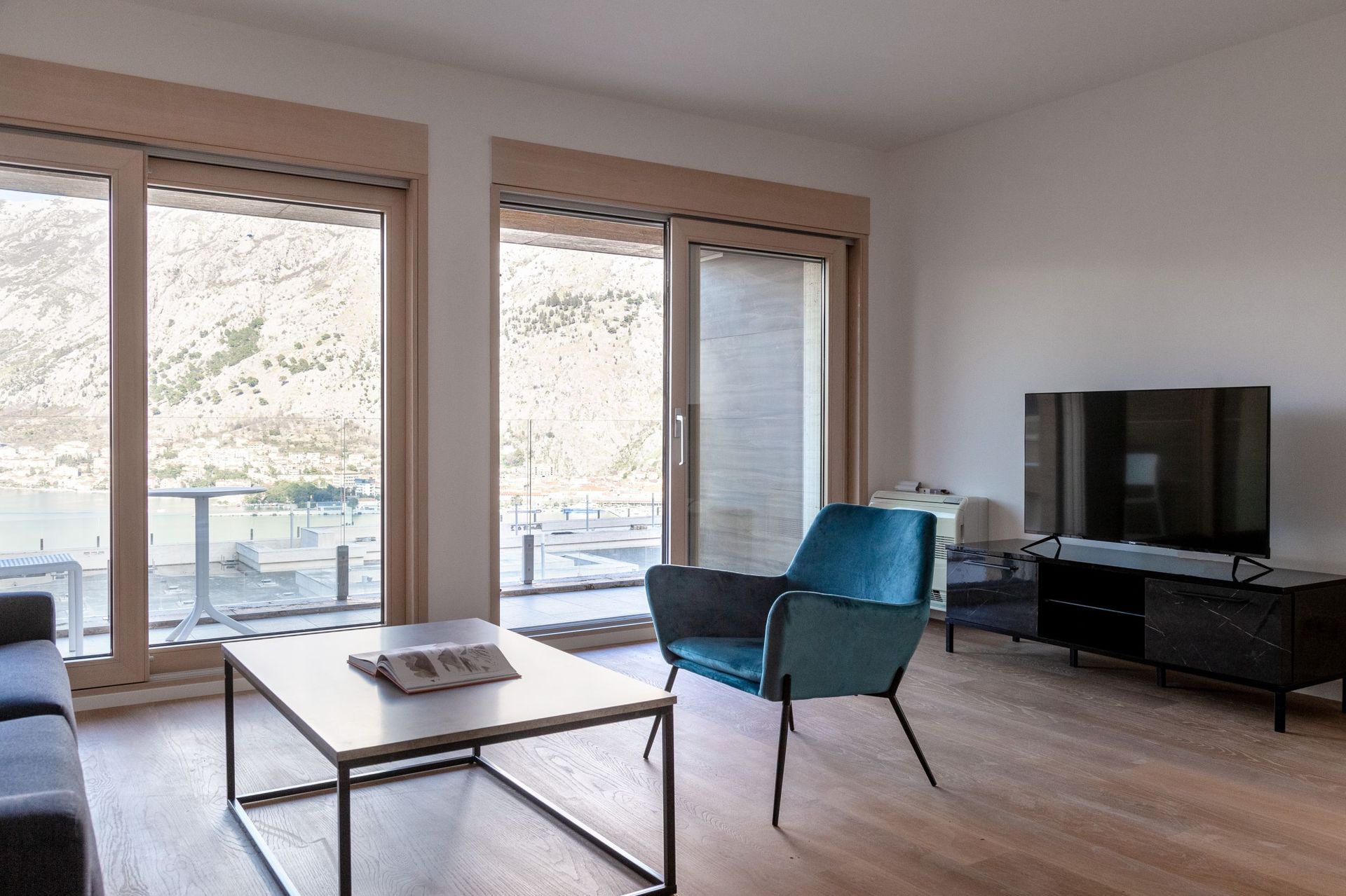 Wohnzimmer mit Panoramablick auf die Bucht von Kotor, moderne Möbel und Terrasse in der Wohnung, Kotor, Montenegro.