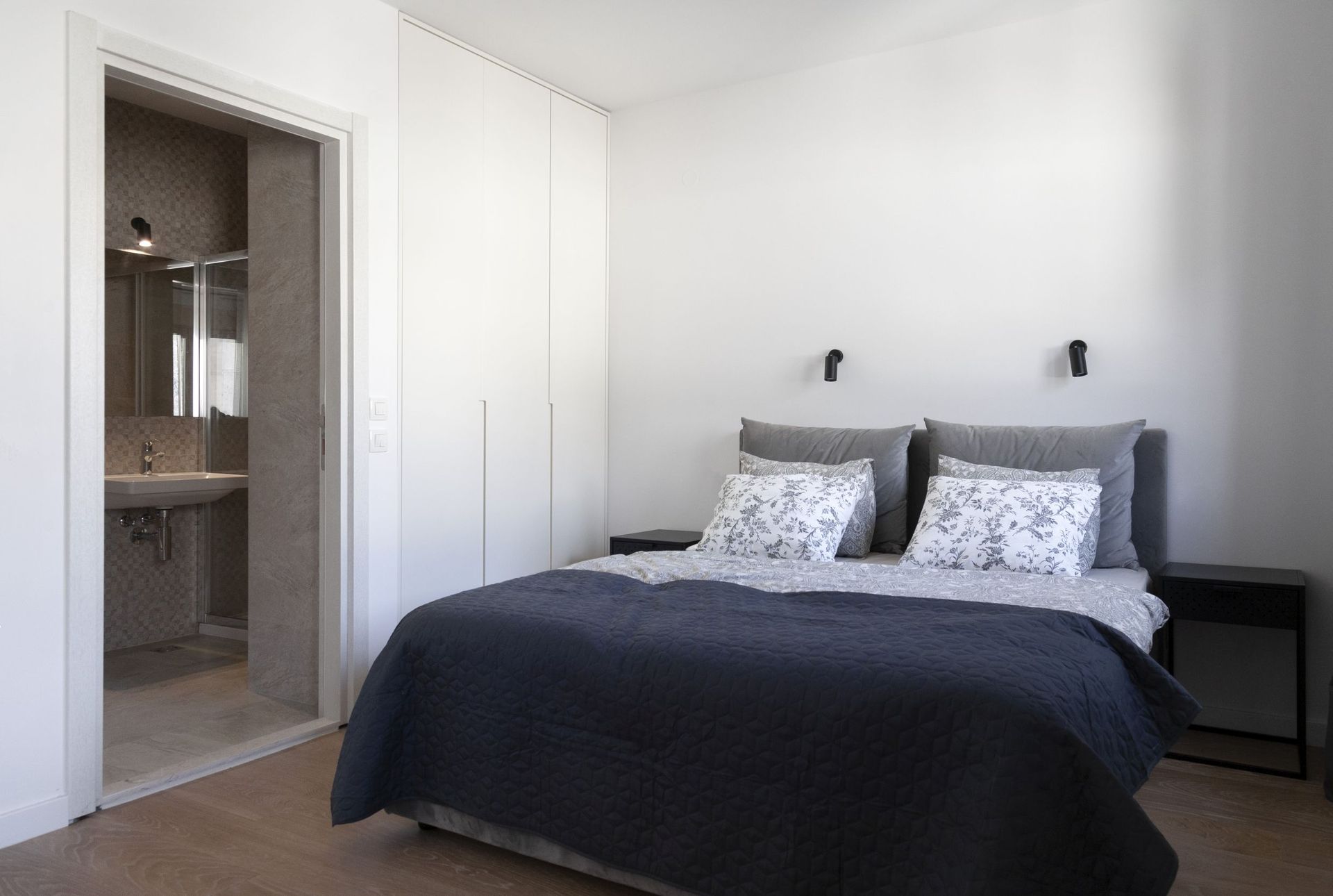 Modernes Schlafzimmer mit Doppelbett und Badezimmer in einer zum Verkauf stehenden Wohnung, Kotor, Montenegro.