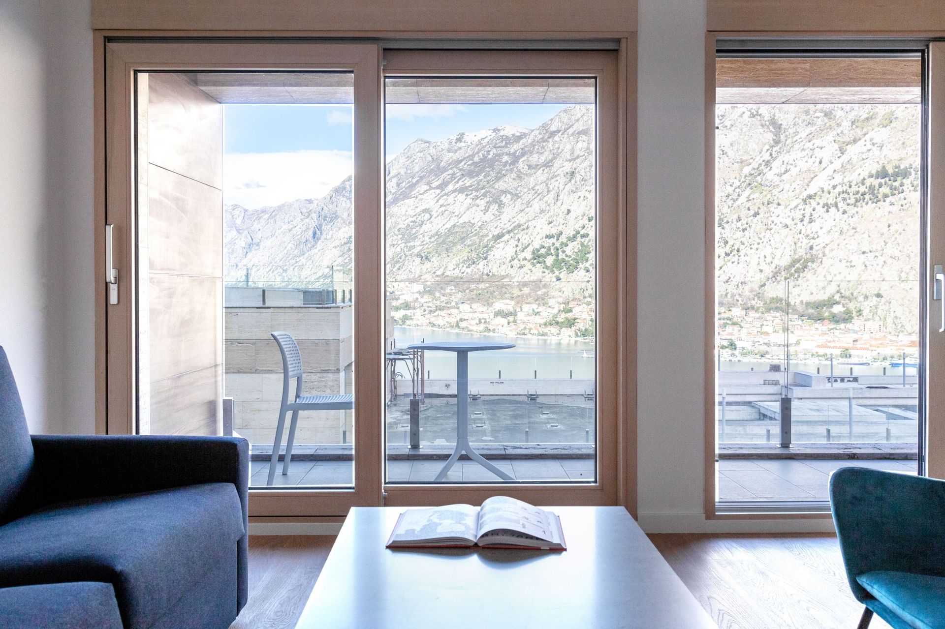 Wohnzimmer mit Panoramablick auf die Bucht von Kotor und die Berge, Wohnung in Kotor, Montenegro, modernes Interieur mit Terrasse.