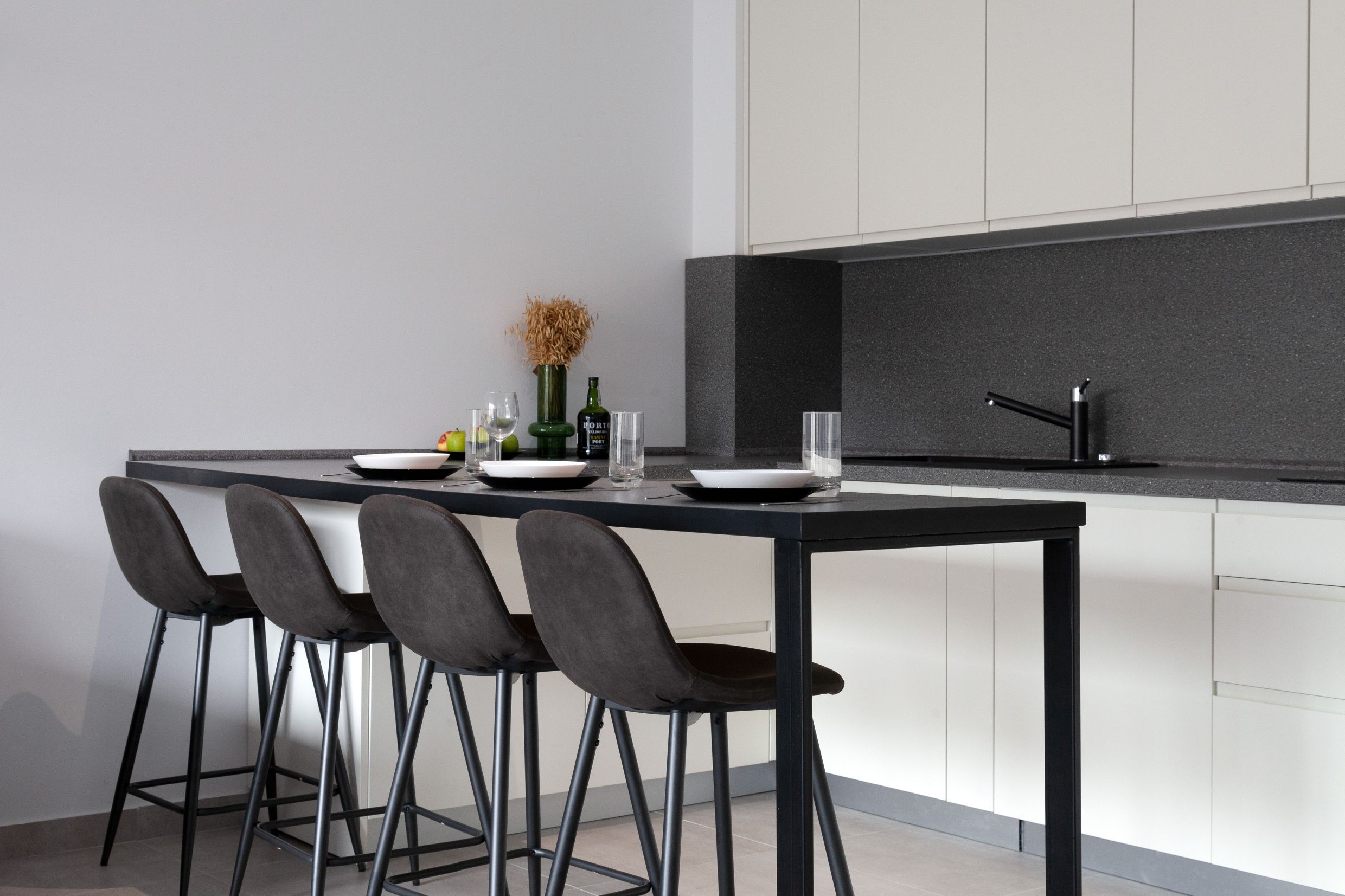 Moderne Küche mit Bartheke und Stühlen in einer Wohnung in Kotor, Montenegro: stilvolles Interieur und helle Möbel.