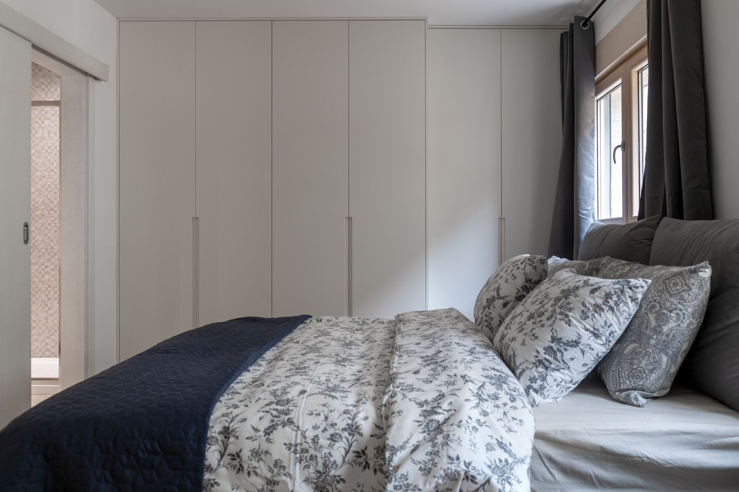 Modernes Schlafzimmer mit großem Einbauschrank und Bett in einer Wohnung, Kotor, Montenegro.