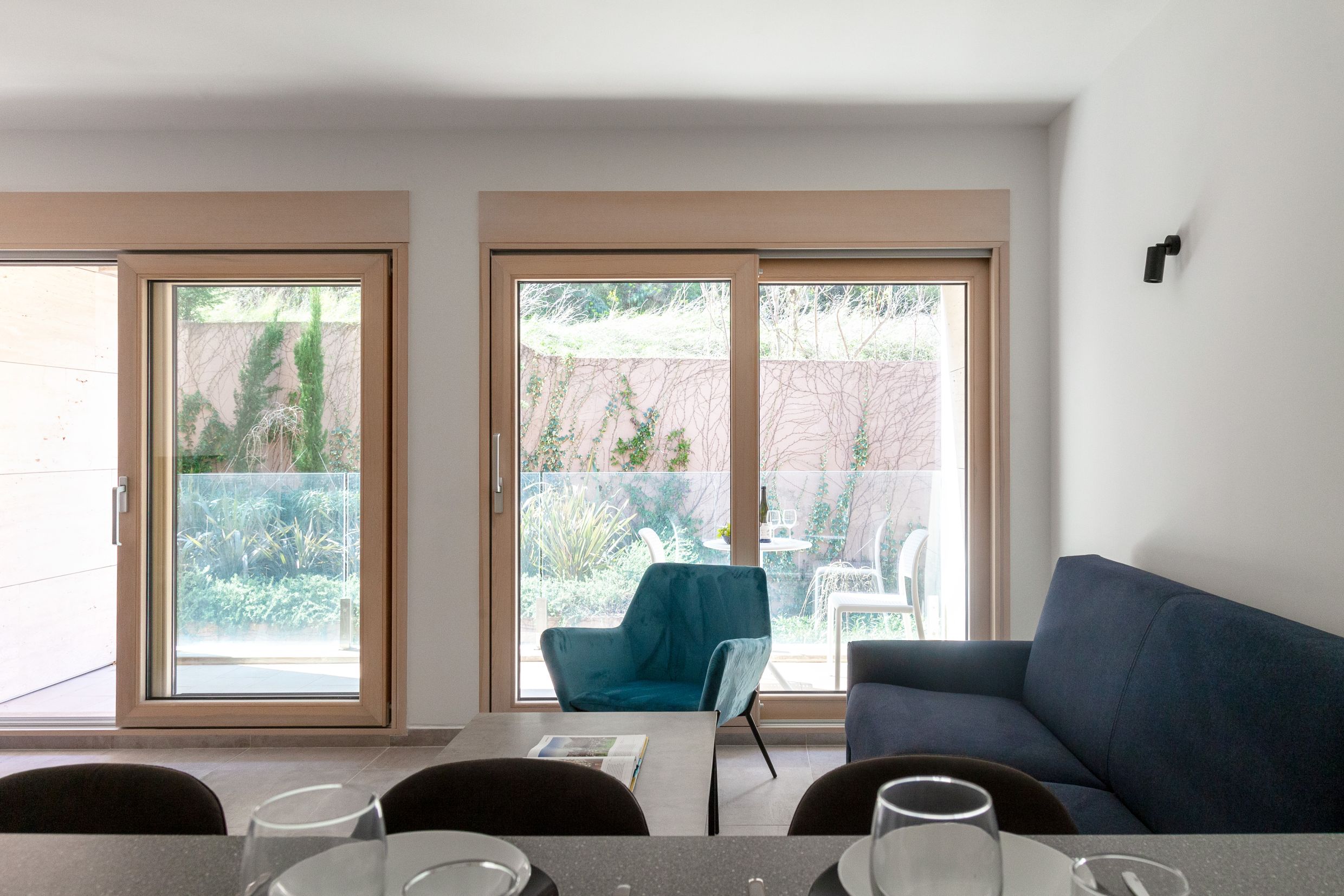 Wohnzimmer in einer Wohnung in Kotor, Montenegro: moderne Möbel, Panoramafenster und Zugang zur Terrasse mit Garten.