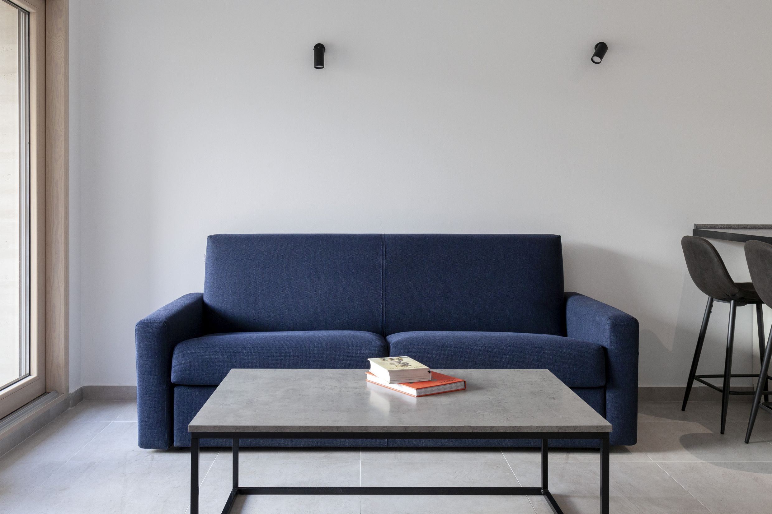 Modernes Wohnzimmer mit blauem Sofa und Couchtisch in einer Wohnung in Kotor, Montenegro.