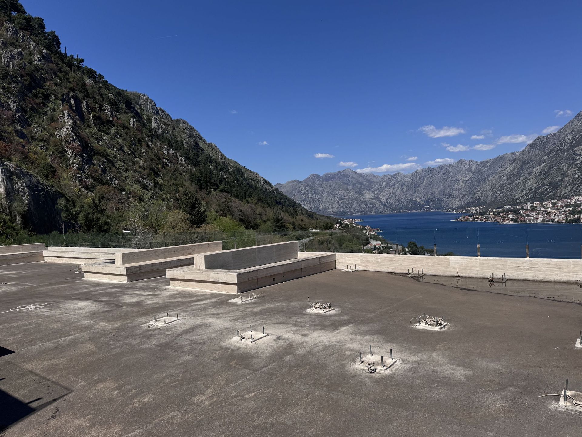 Otvorena terasa sa kamenim klupama i panoramskim pogledom na Bokokotorski zaliv i planine, Crna Gora.