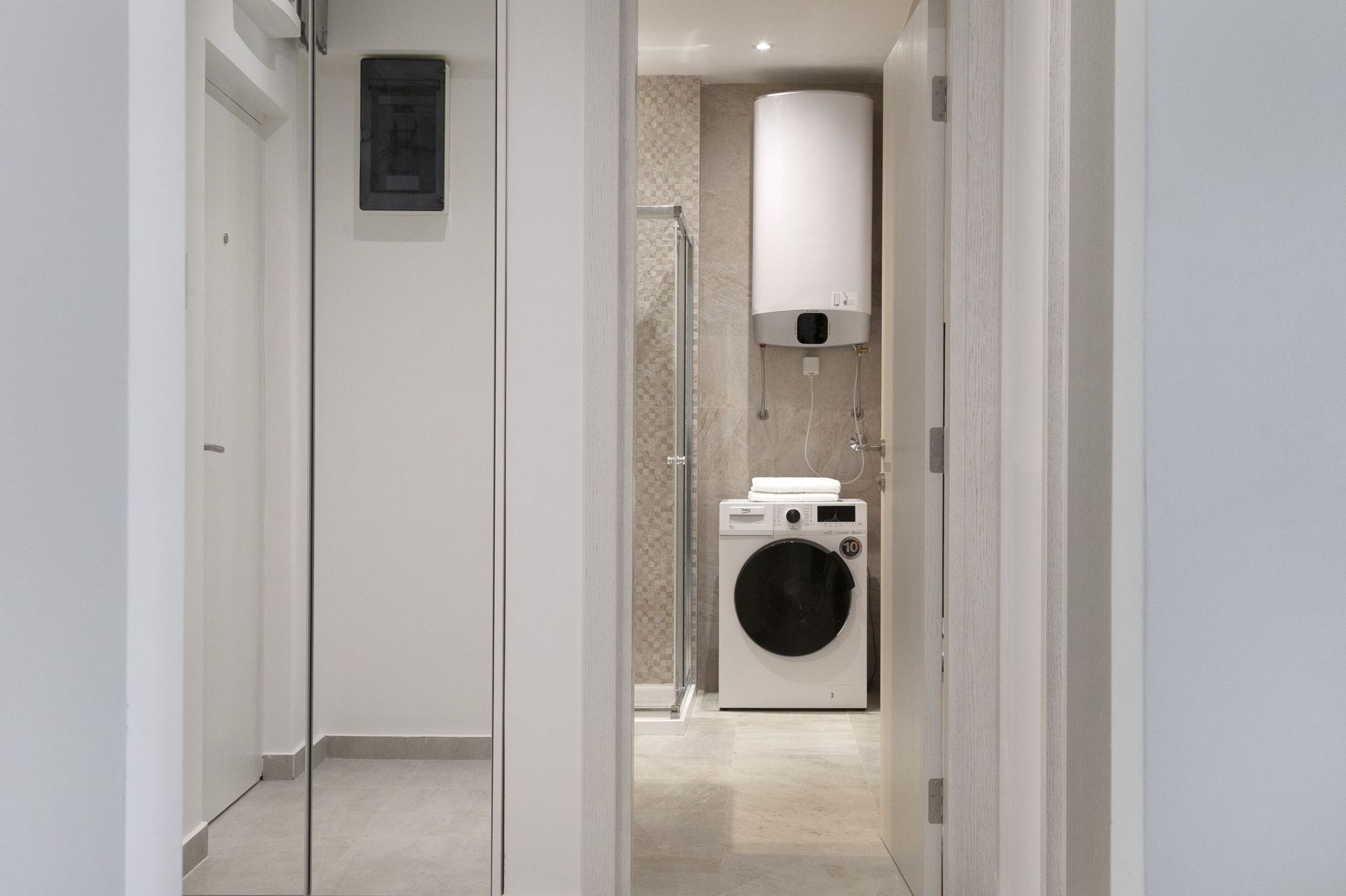 Modernes Badezimmer in einer Wohnung in Kotor, Montenegro: Duschkabine, Waschmaschine und Boiler.