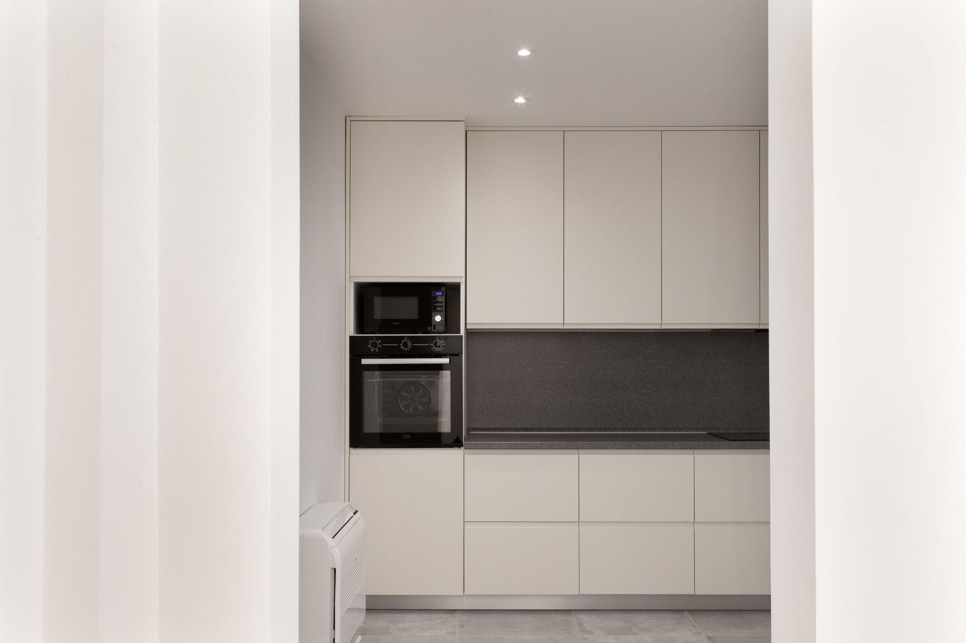 Moderne helle Küche mit Einbaugeräten in einer Wohnung in Kotor, Montenegro. Minimalistisches Innendesign.