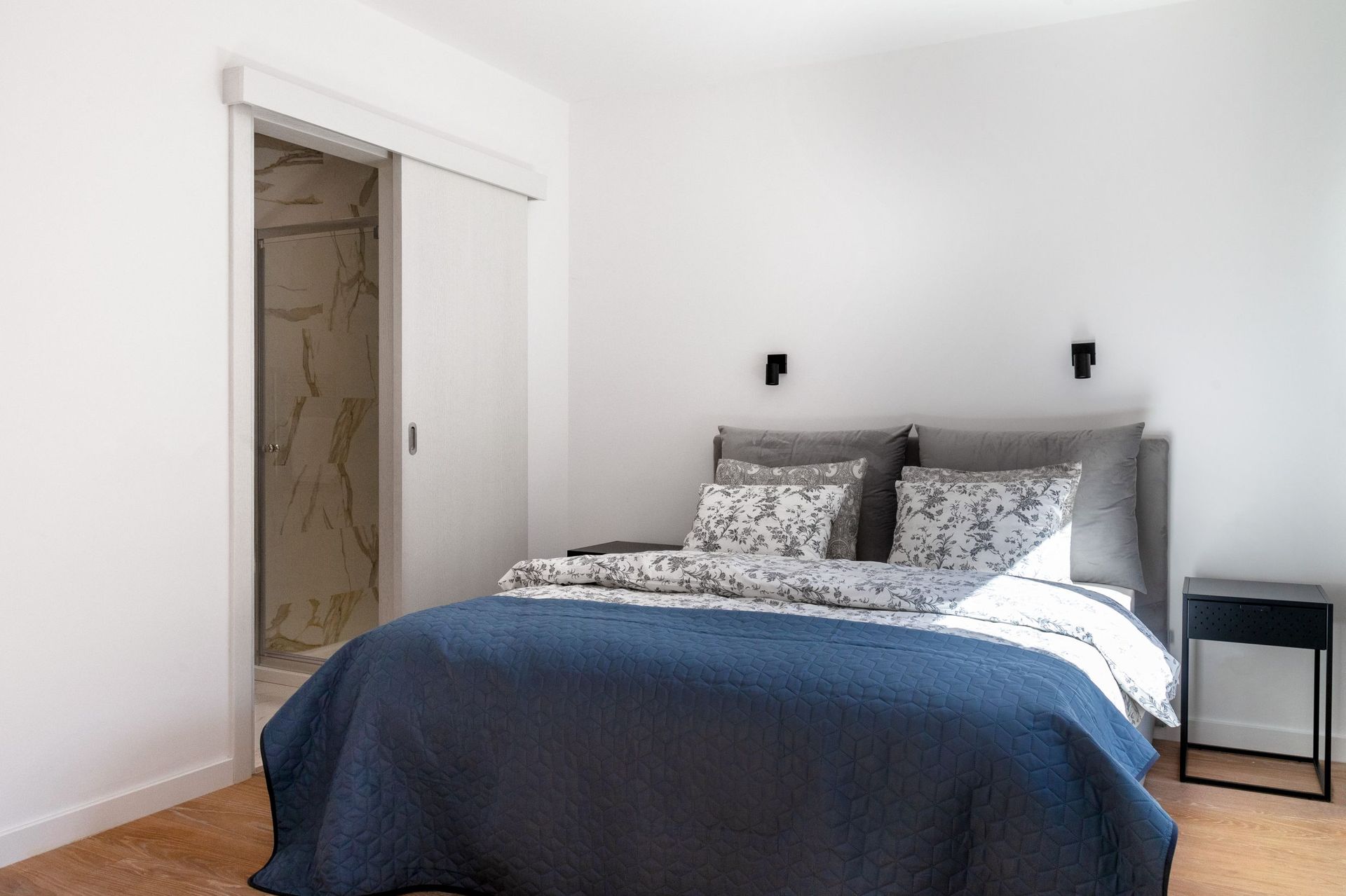 Modernes Schlafzimmer mit Doppelbett und Badezimmer in einer Wohnung in Kotor, Montenegro.