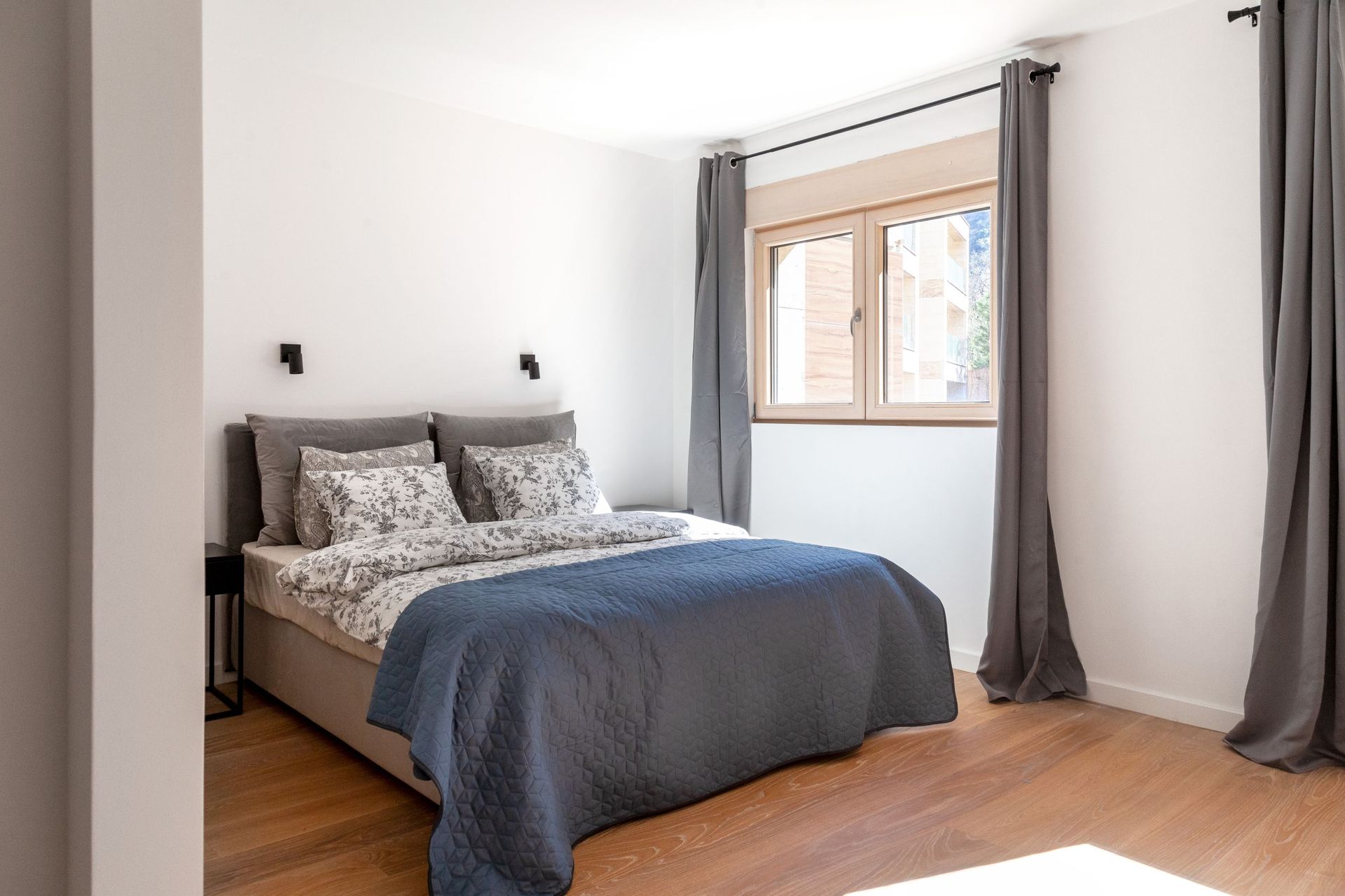 Helles Schlafzimmer mit Doppelbett und Holzboden in einer Wohnung in Kotor, Montenegro.