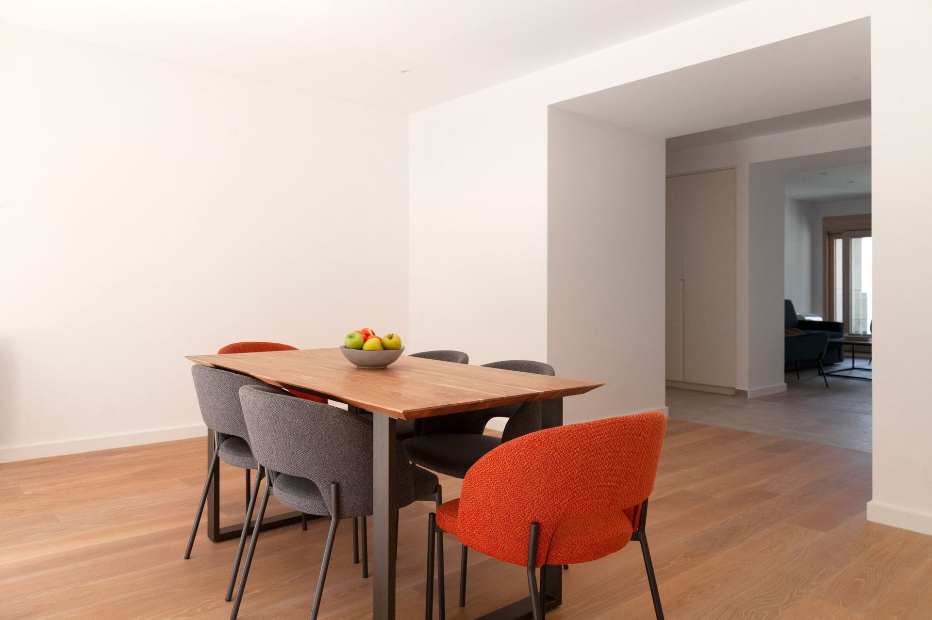 Moderner Essbereich mit Holztisch und bunten Stühlen in einer Wohnung, Kotor, Montenegro.