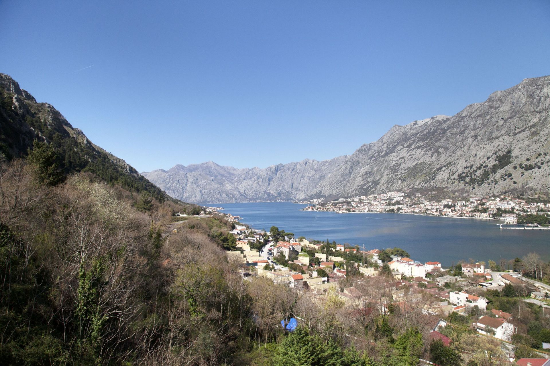 Panoramablick auf die Bucht von Kotor und die Berge aus einer Wohnung in Kotor, Montenegro: Küstenstadt und Meereslandschaft.