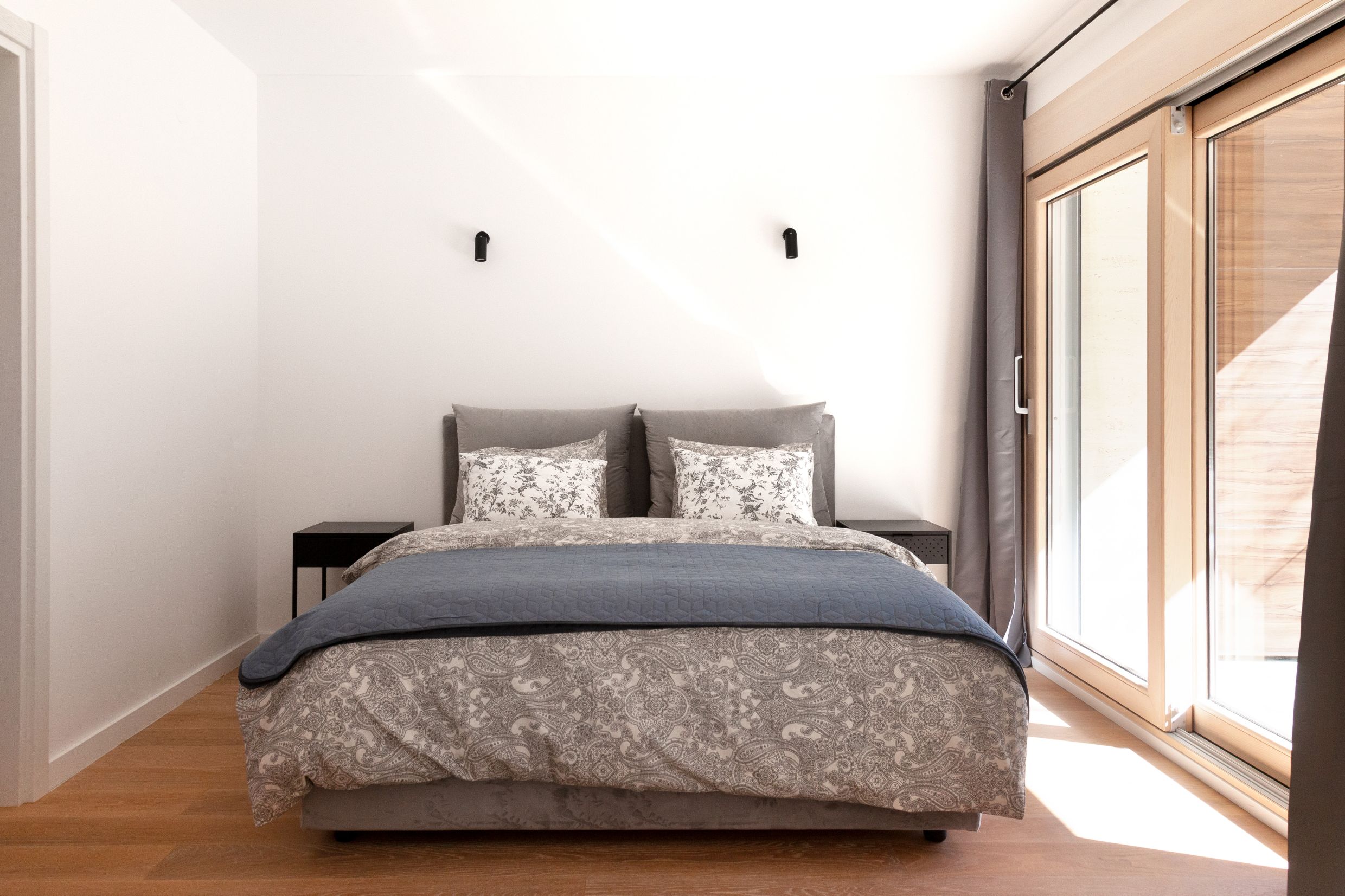 Modernes Schlafzimmer mit Doppelbett und Panoramafenster in einer Wohnung in Kotor, Montenegro.