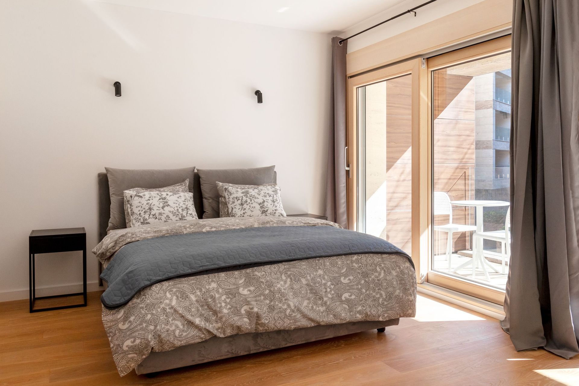 Modernes Schlafzimmer in einer Wohnung in Kotor, Montenegro: Doppelbett, Panoramafenster und Zugang zur Terrasse.