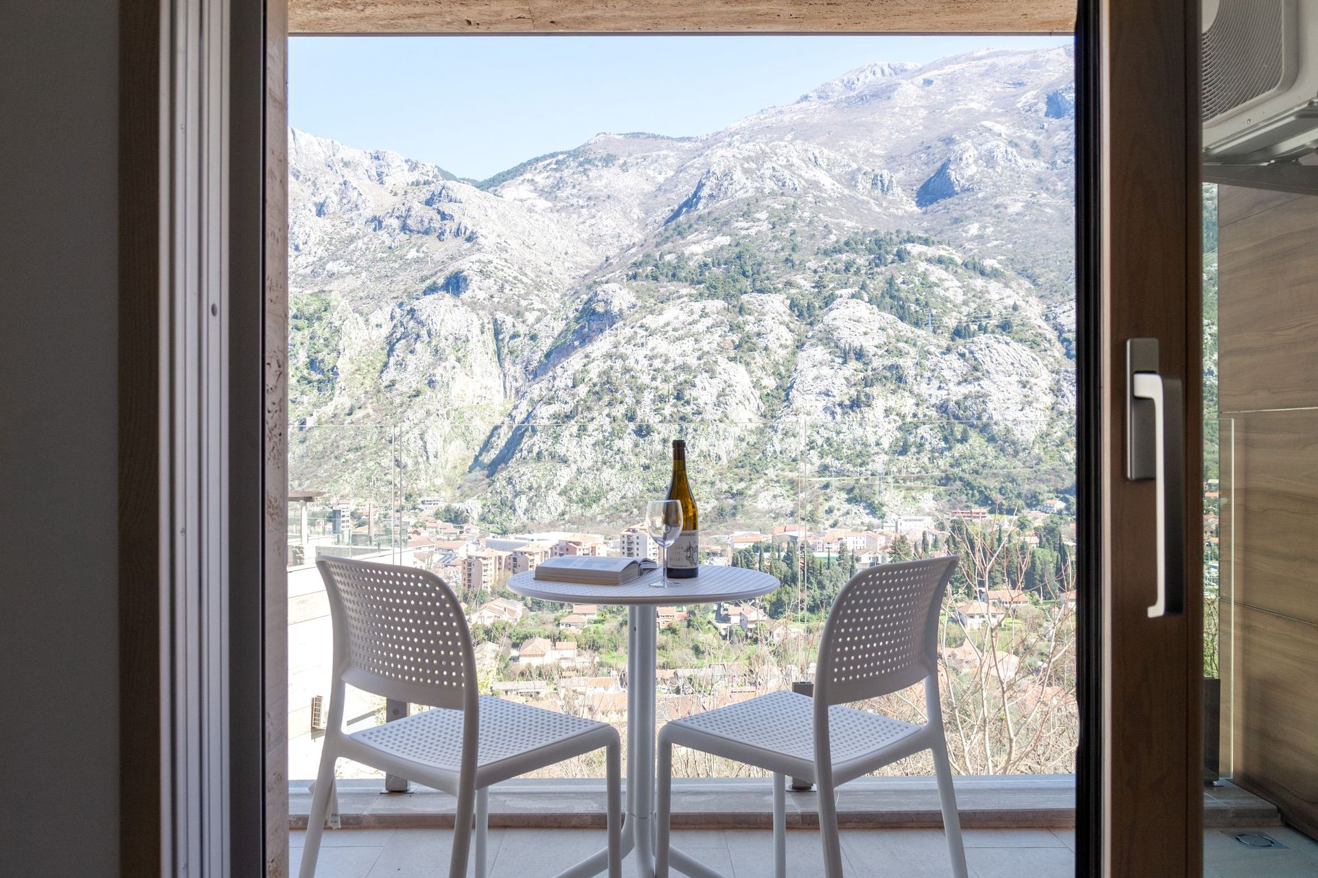 Balkon mit weißen Möbeln und Panoramablick auf die Berge und die Stadt Kotor, Montenegro. Wohnung Nr. 2562 mit Terrasse.