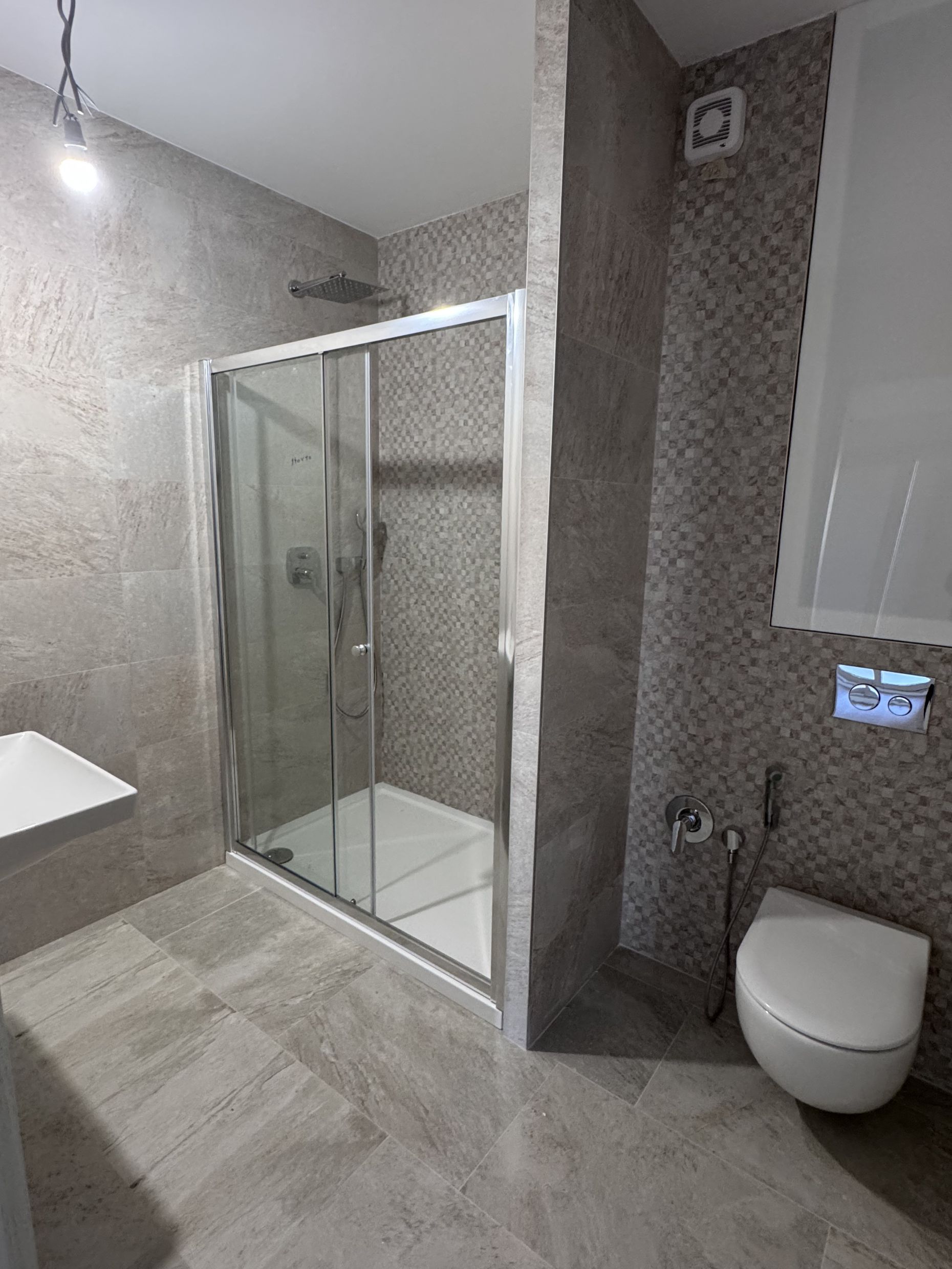 Modern bathroom with a shower cabin and tiled finishes in an apartment in Kotor, Montenegro.