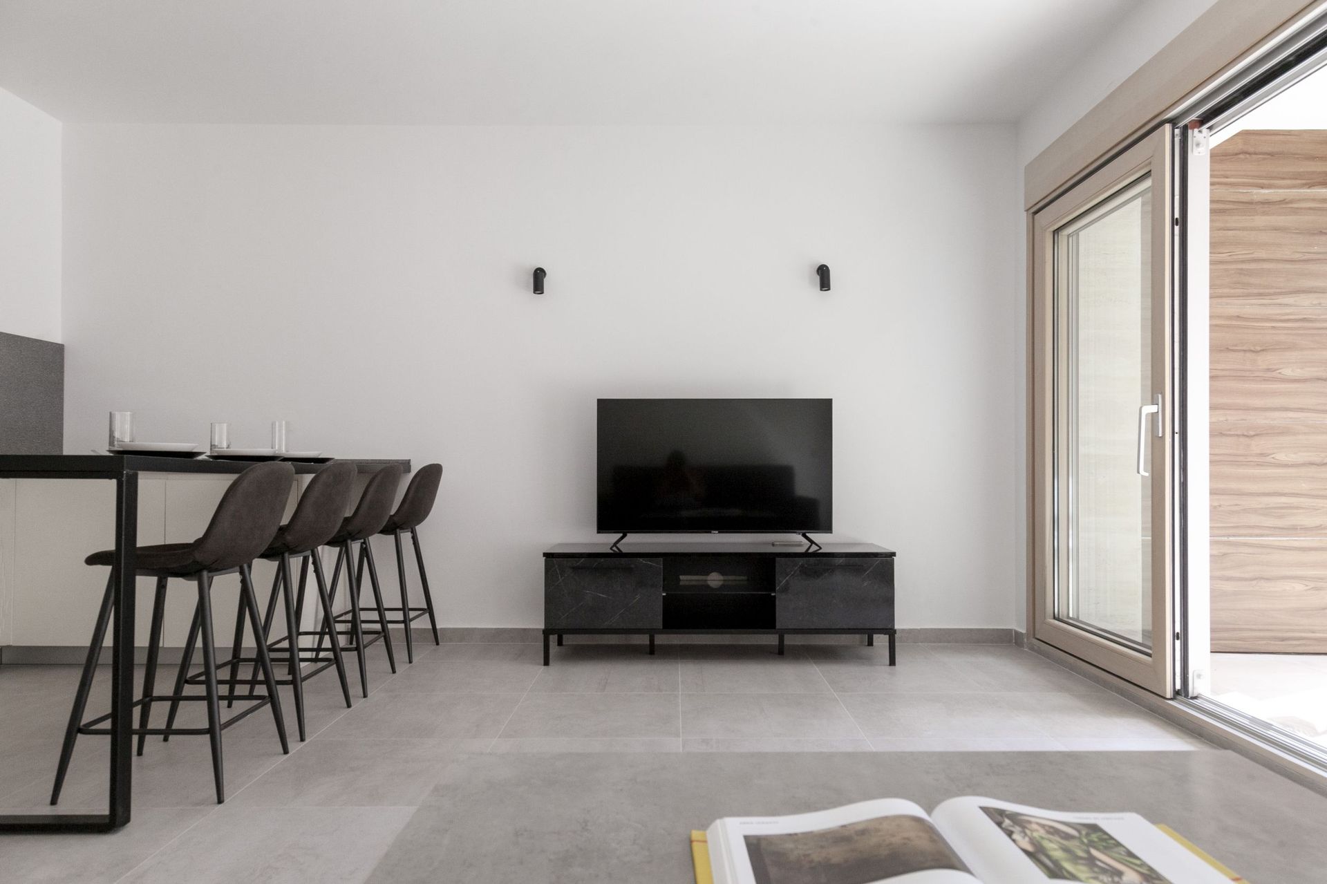 Modernes Wohnzimmer mit Bartheke und TV-Bereich in einer Wohnung in Kotor, Montenegro: minimalistisches Interieur.