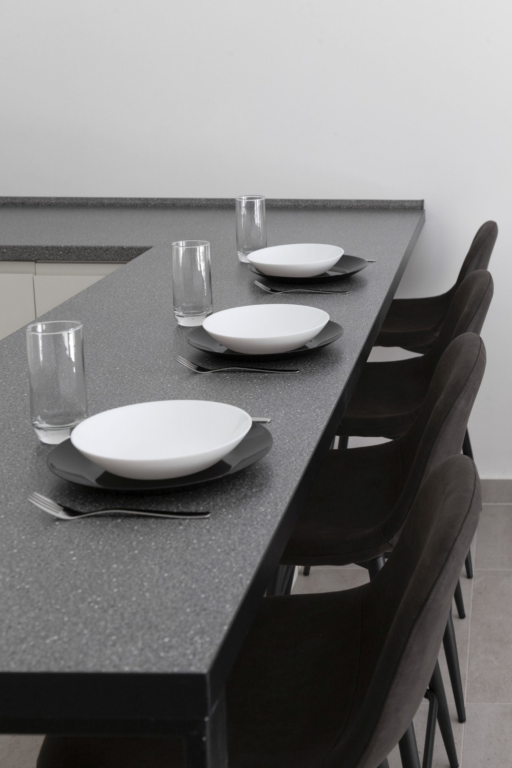 Moderne Küche in einer Wohnung in Kotor, Montenegro: Bartheke mit gedecktem Tisch, dunkle Stühle und stilvolles Interieur.