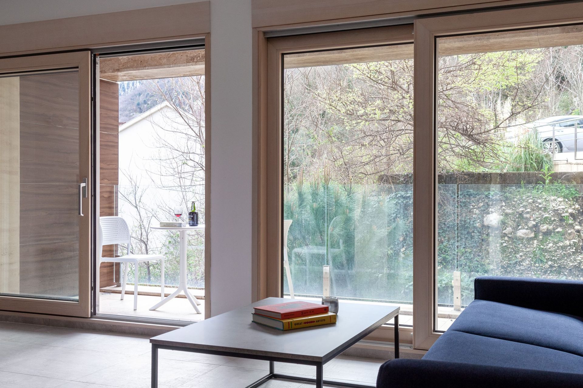Wohnzimmer mit Panoramafenstern und Zugang zur Terrasse in einer Wohnung in Kotor, Montenegro: modernes Interieur und Aussicht.