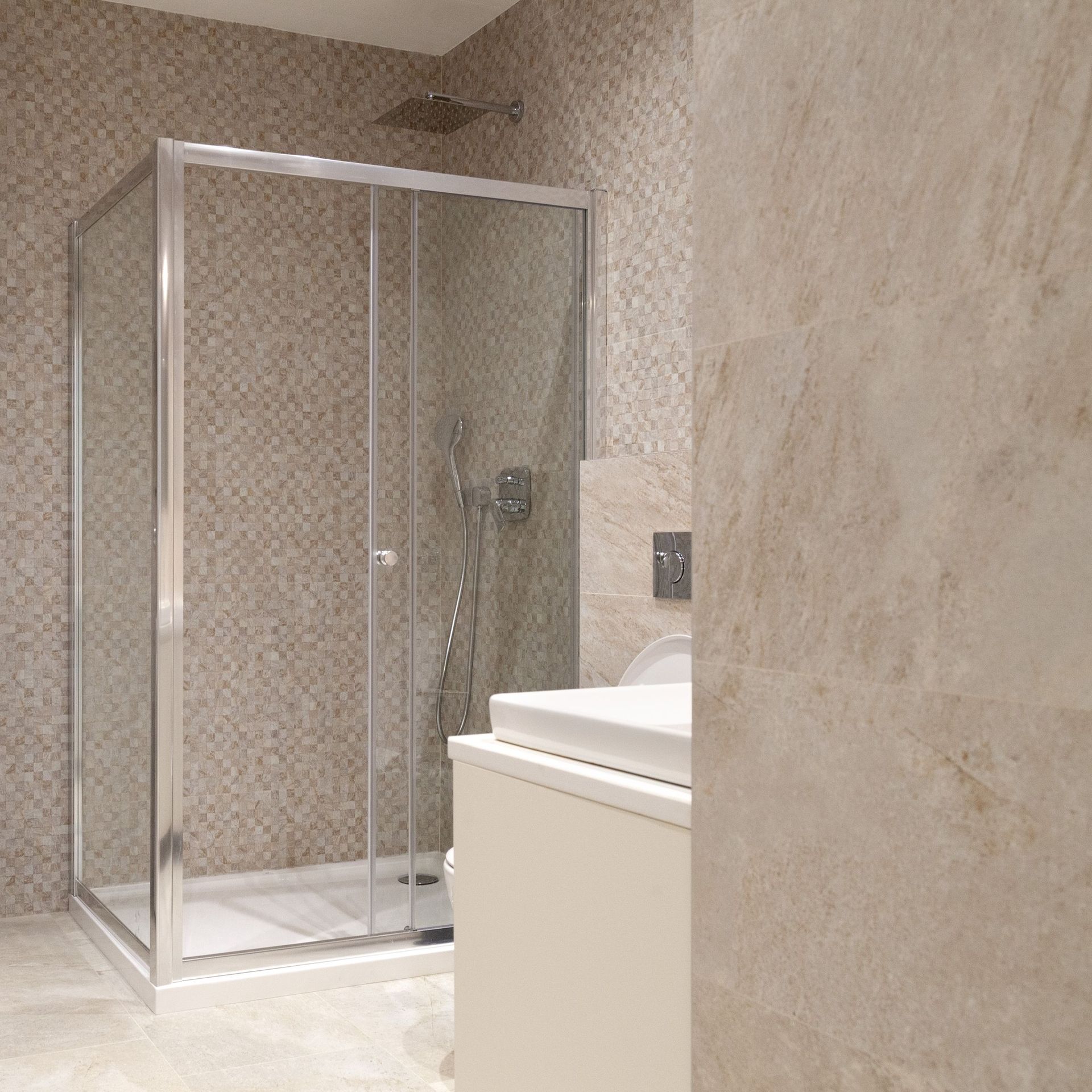 Modernes Badezimmer in einer Wohnung in Kotor, Montenegro: Duschkabine, helle Fliesen und hochwertige Sanitäranlagen.