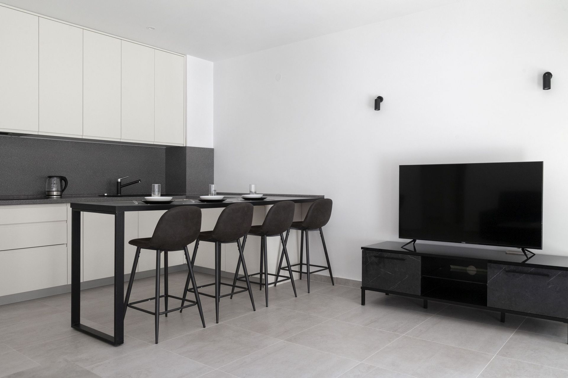 Moderne Wohnküche mit Bar in einer Wohnung in Kotor, Montenegro: stilvolles Interieur in Schwarz-Weiß.