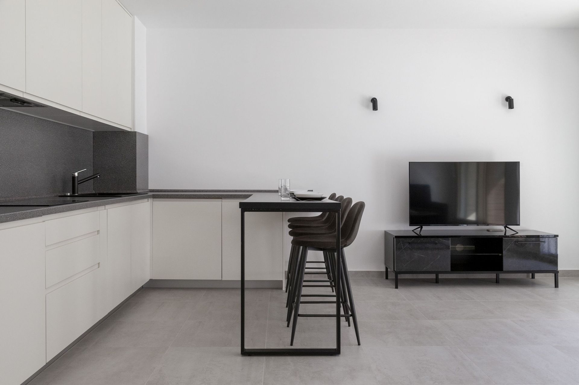 Moderne Wohnküche mit Bar und TV-Bereich in einer Wohnung, Kotor, Montenegro. Minimalistisches Interieur.