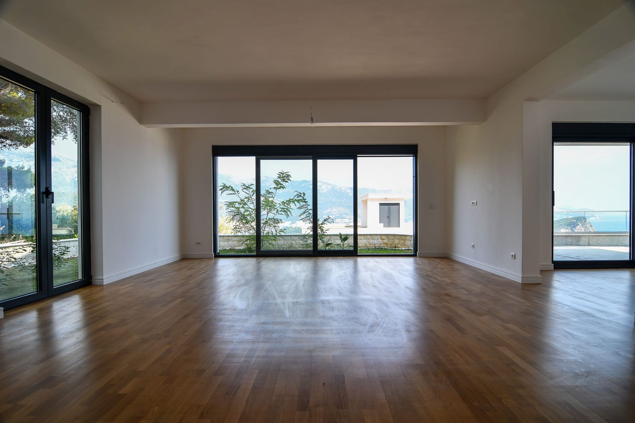 Geräumiges Wohnzimmer mit Panoramafenstern und Blick auf das Meer und die Berge in einer Villa, Budva, Montenegro.