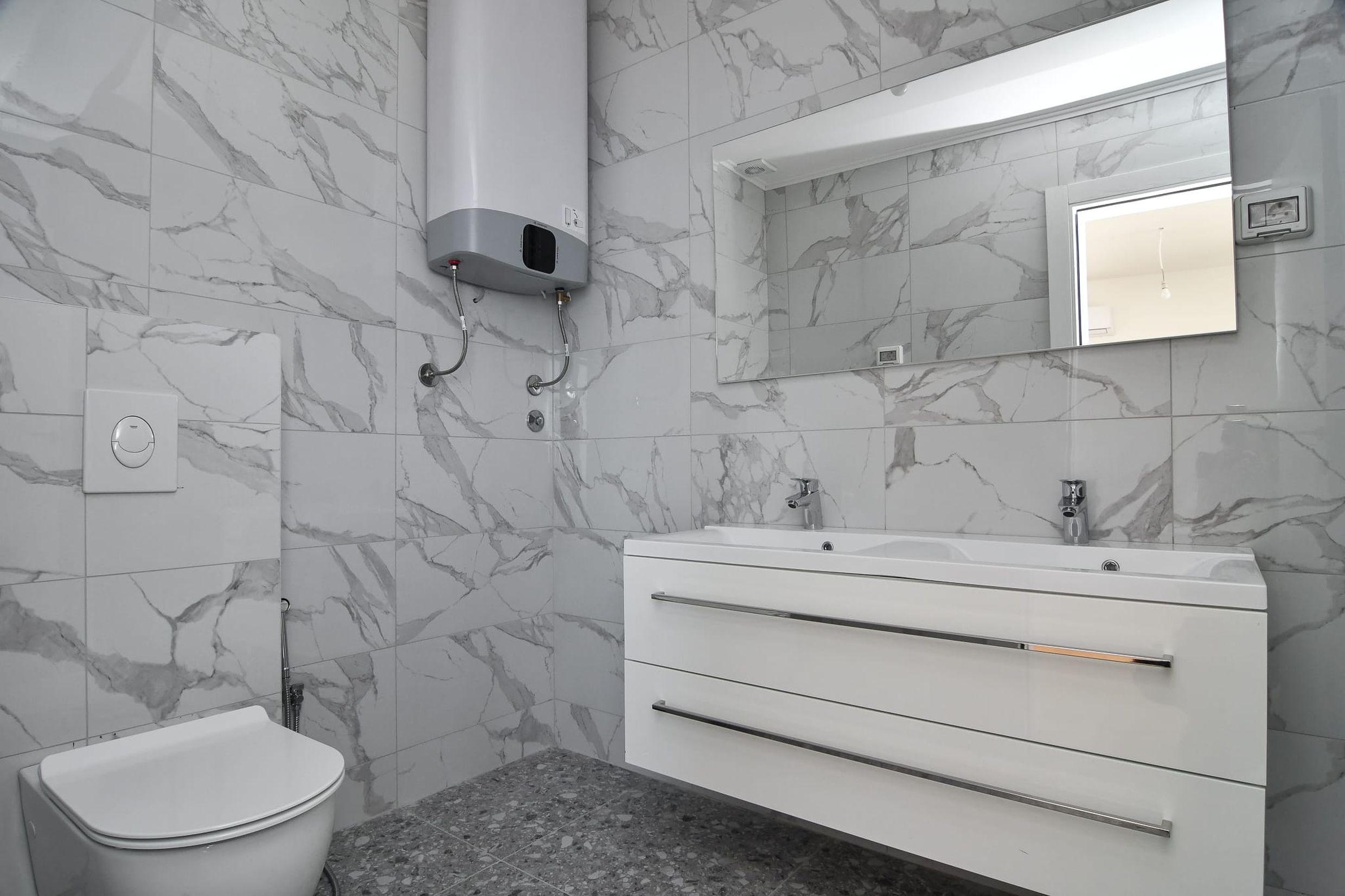 Modernes Badezimmer mit Marmoroptik in einer Villa, Budva, Montenegro: Waschtisch und Boiler.