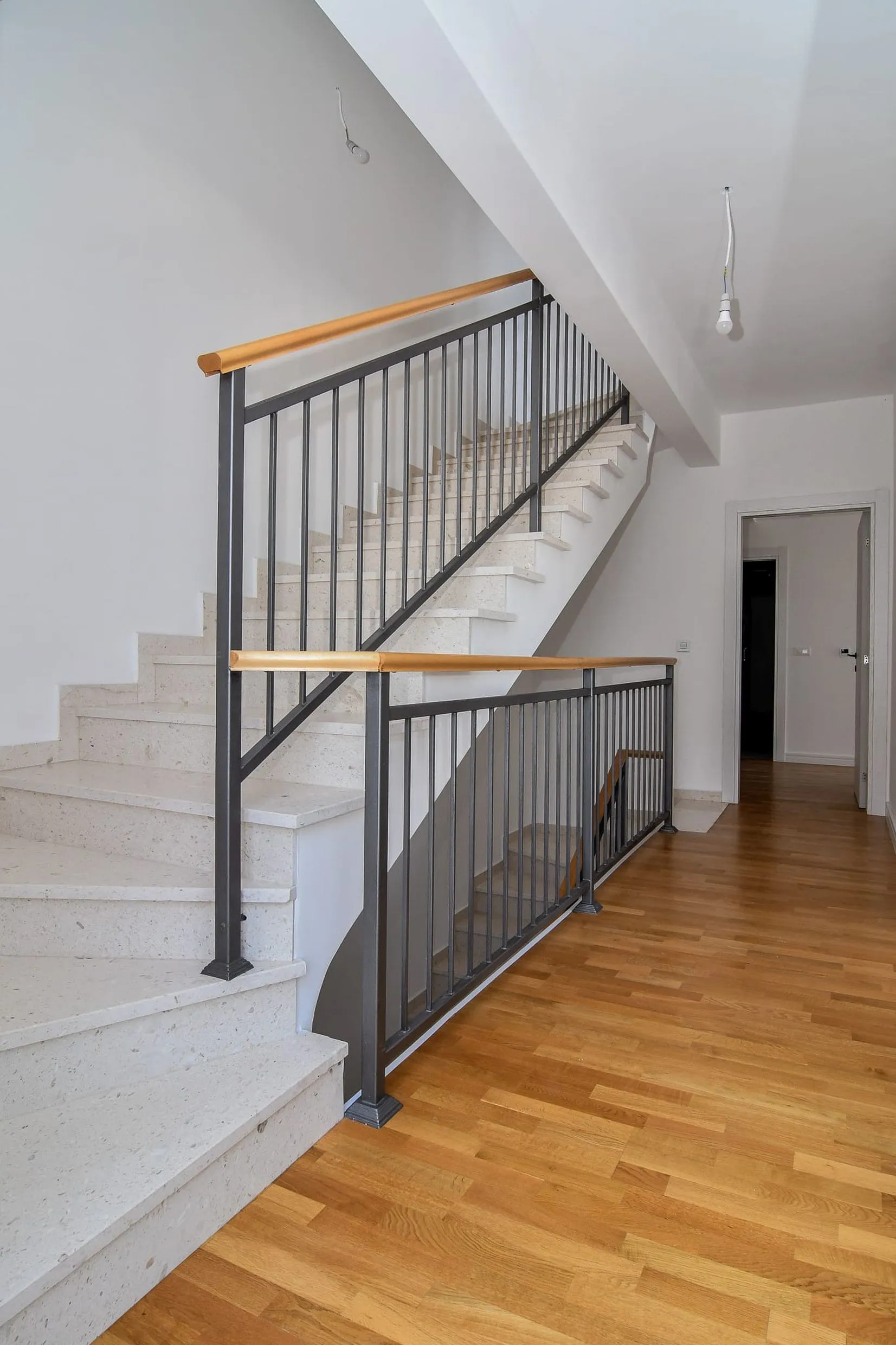 Escalier avec marches en pierre et rampe en fer forgé dans l’intérieur d’une villa moderne à Budva, Monténégro.