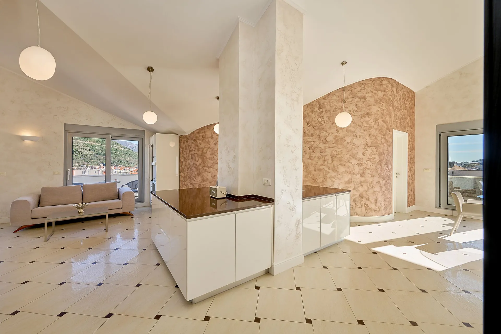 Hell wohnzimmer mit beige sofa, weißer kücheninsel, dekorigierten texturierten wänden und fliesenboden.