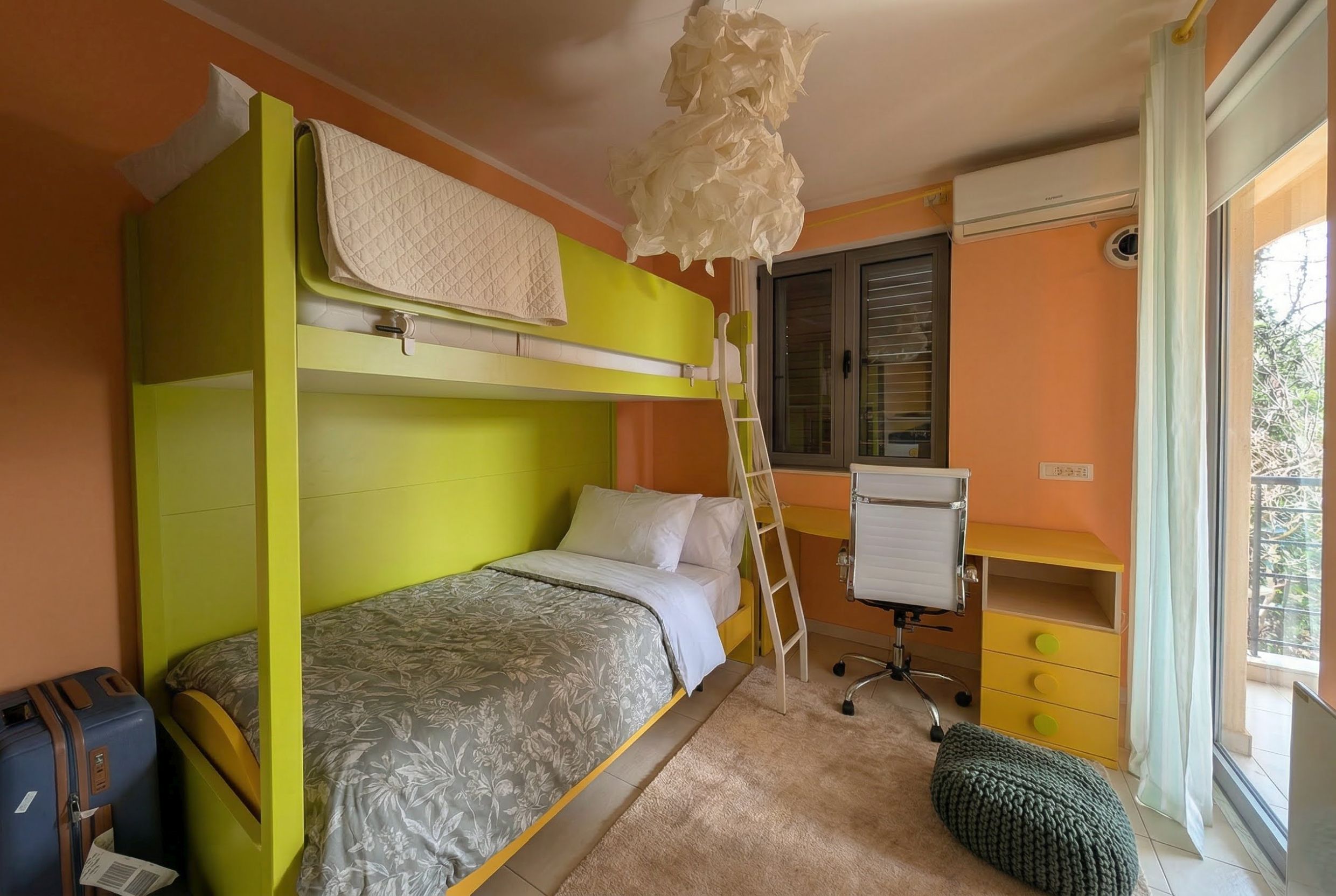 Kinderzimmer mit Etagenbett, Schreibtisch und Zugang zum Balkon in einer Wohnung, Bečići, Montenegro.