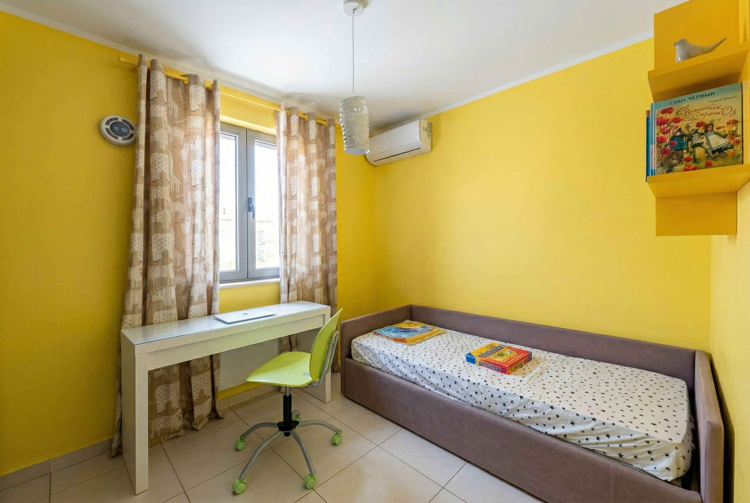 Kinderzimmer mit gelben Wänden, Bett und Schreibtisch in einer Wohnung in Bečići, Montenegro.