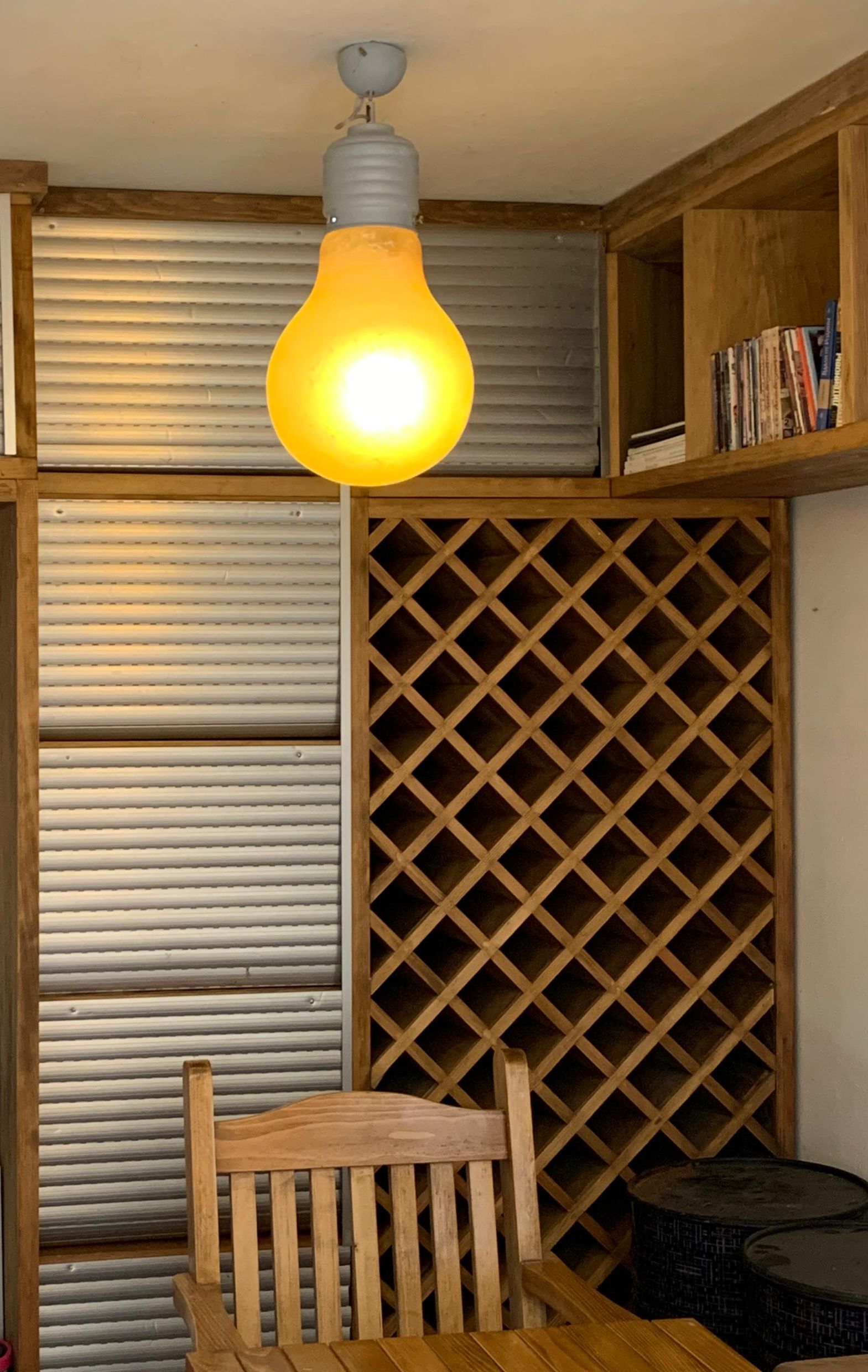 Wnętrze salonu w mieszkaniu w Dobrocie, Czarnogóra: drewniany regał na wino, stylowa lampa i przytulne meble.