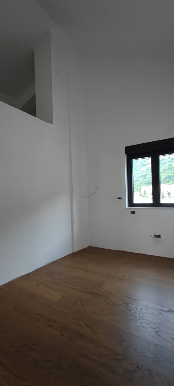 Wohnzimmer in einem Penthouse in Budva, Montenegro: heller Raum mit bezugsfertiger Ausstattung, Parkettboden und Bergblick.