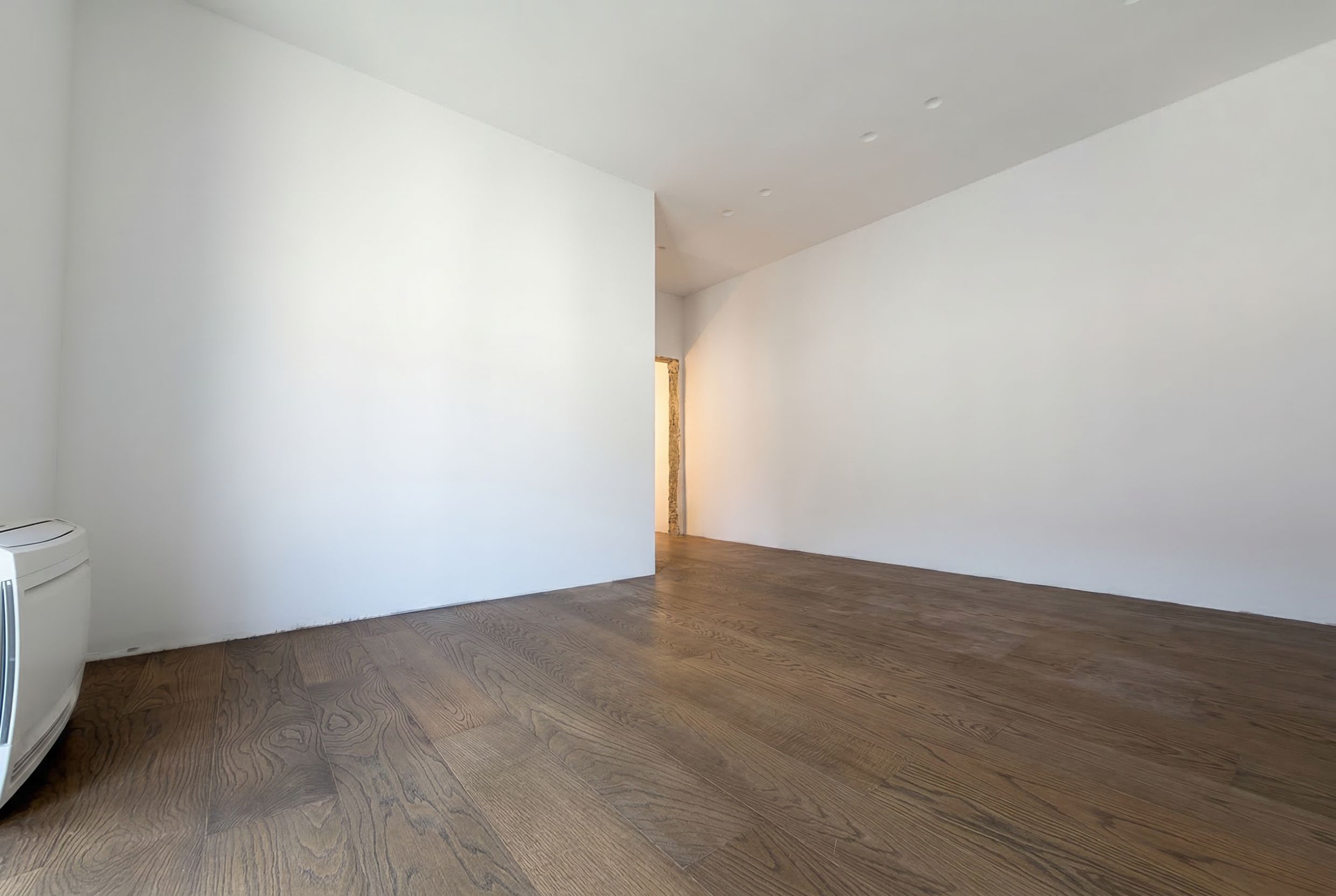 Helles Wohnzimmer mit Parkettboden in einem Penthouse in Budva, Montenegro. Modernes Interieur mit weißen Wänden.