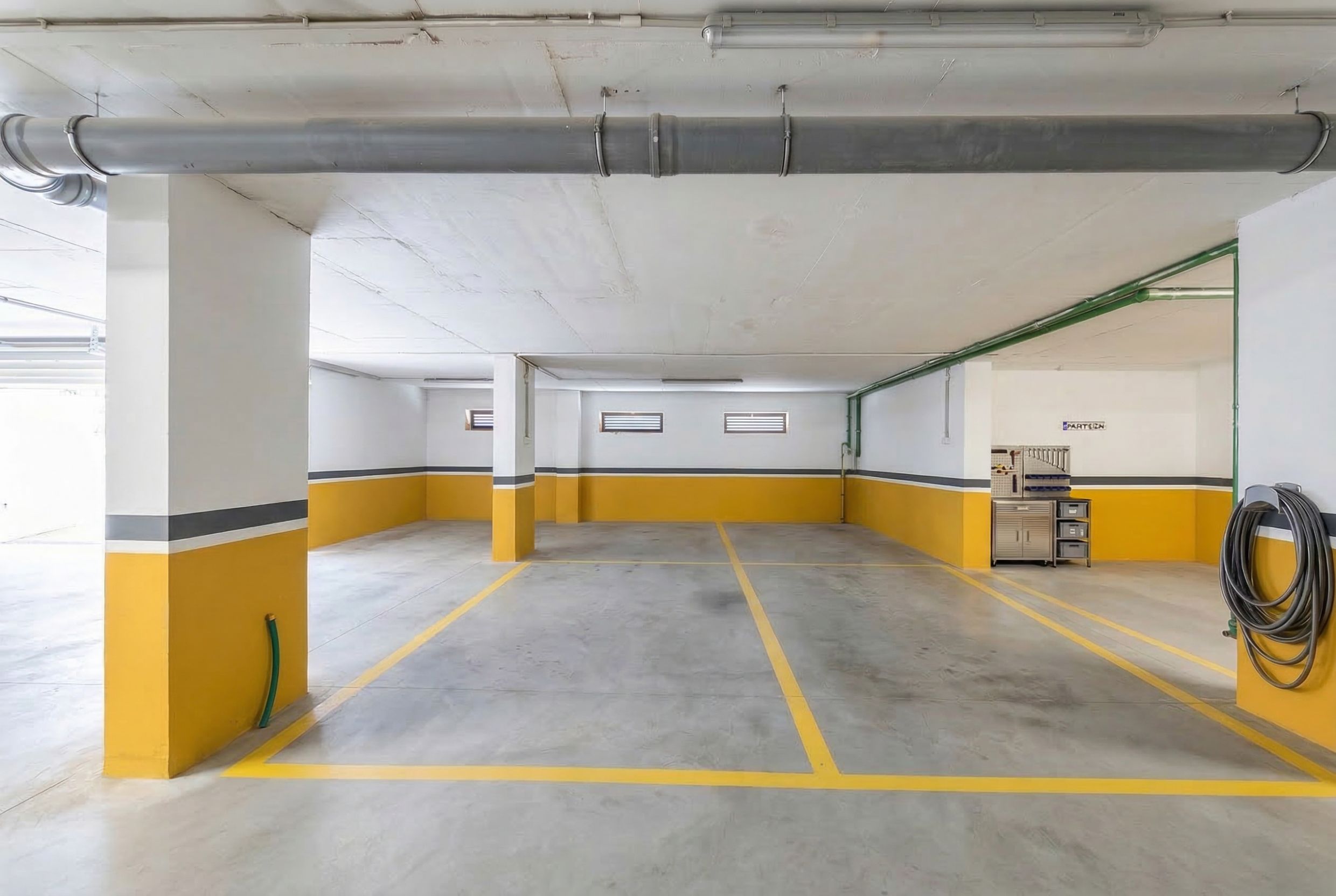 Geräumiger überdachter Parkplatz mit Markierungen in einer Wohnanlage, Budva, Montenegro. Stellplatz mit zusätzlichem Stauraum für Werkzeuge.