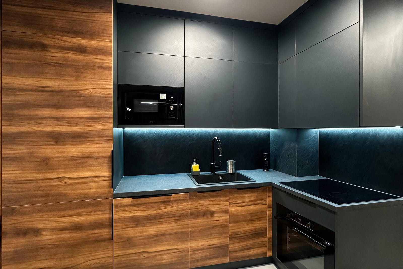 Modern kitchen in an apartment in Budva: dark matte facades, wood textures, built-in appliances and lighting, Montenegro
