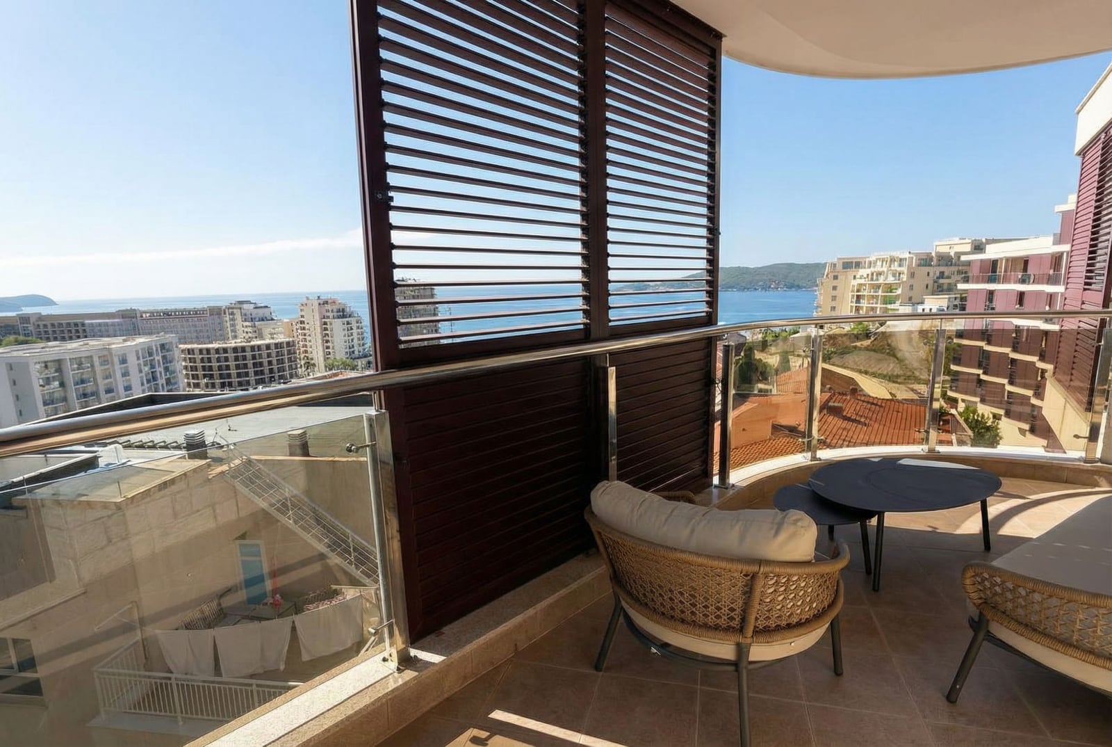 Balkon z plecionymi meblami i panoramicznym widokiem na morze w apartamencie, Rafailovici, Czarnogóra