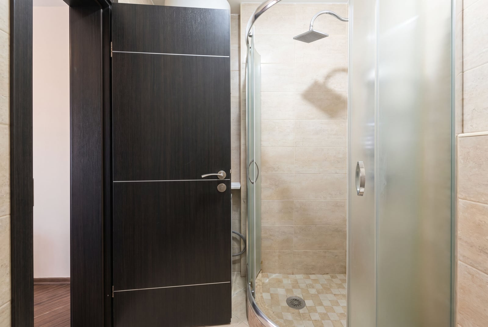 Modernes Badezimmer mit Duschkabine und dunkler Zimmertür in einer Wohnung in Budva, Montenegro