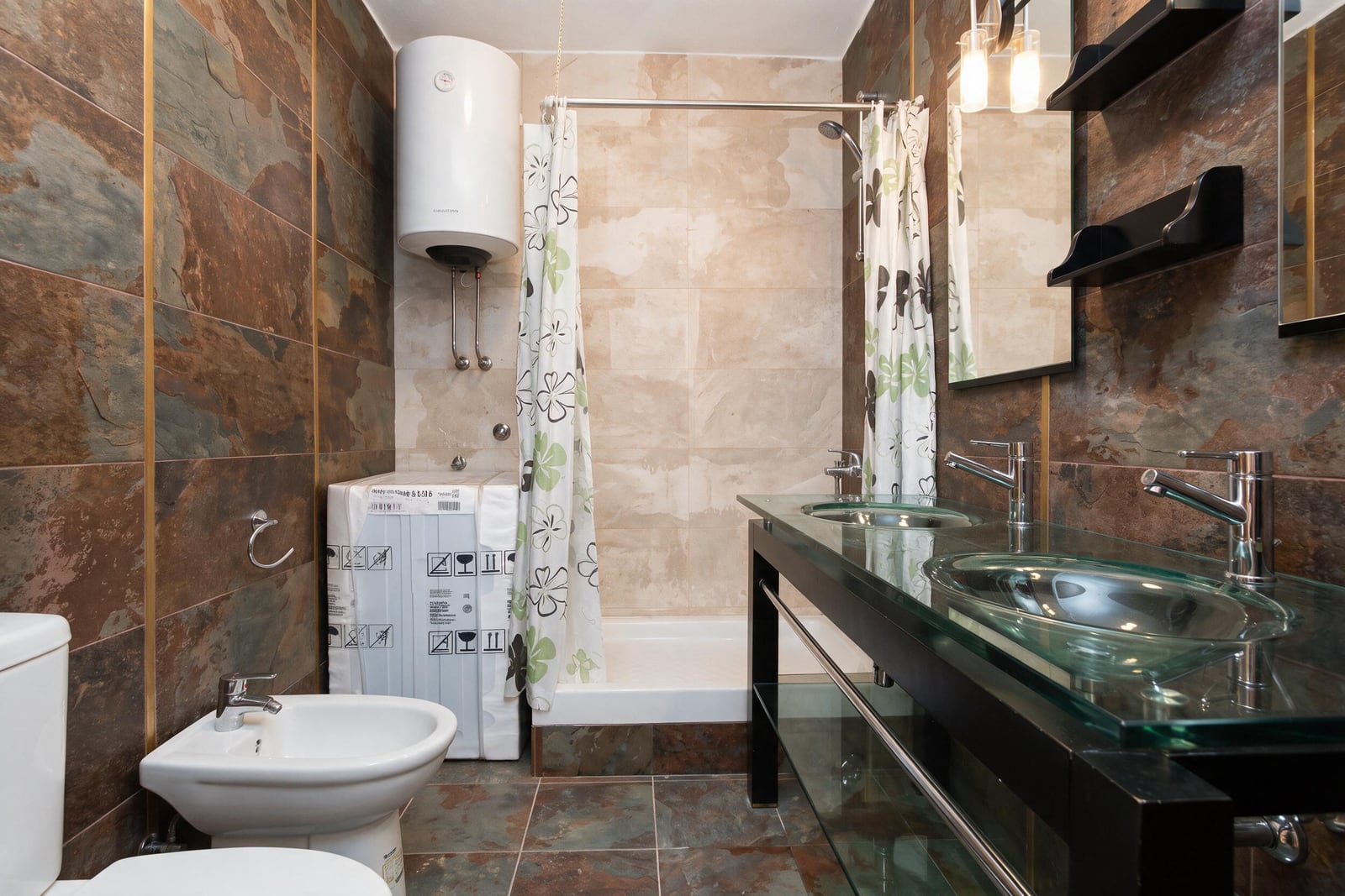 Modern bathroom with a shower cabin, double sink, and water heater in a house in Tivat, Montenegro.
