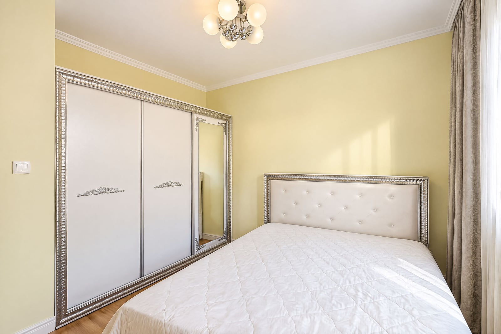Bright bedroom with a double bed and a large built-in wardrobe in an apartment in Budva, Montenegro
