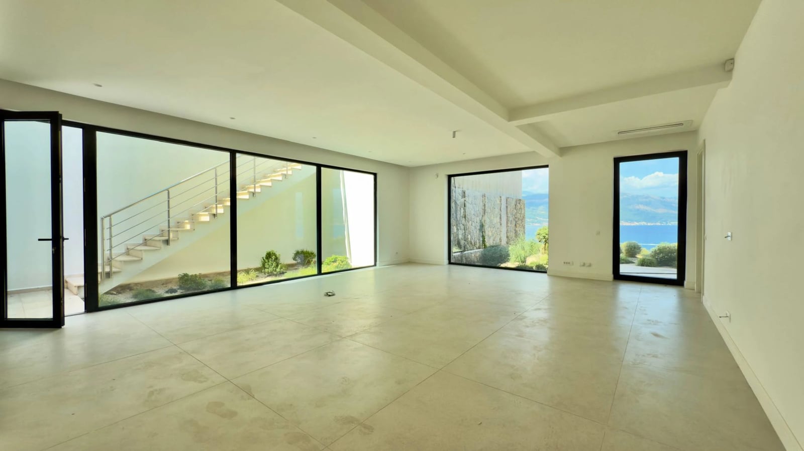 Geräumiges Wohnzimmer mit Panoramafenstern und Meerblick in einer modernen Villa, Krašići, Montenegro.