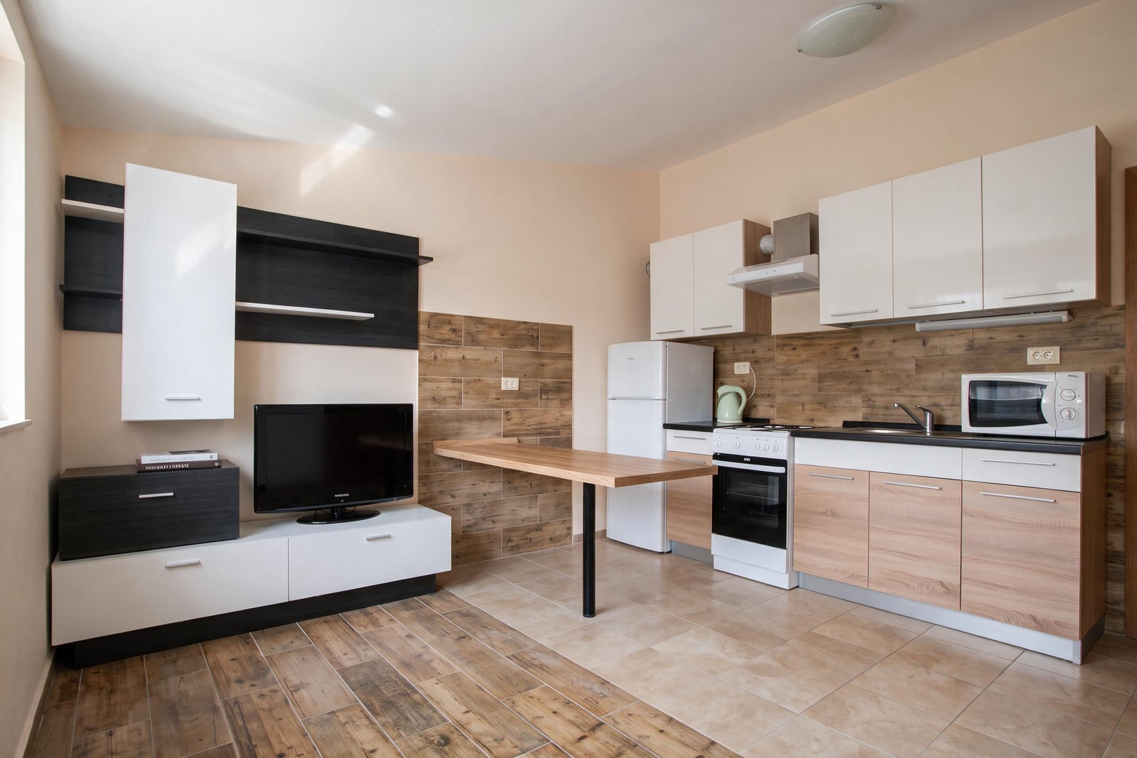 Modern kitchen-living room with furniture, appliances, and a TV area in a house in Tivat, Montenegro