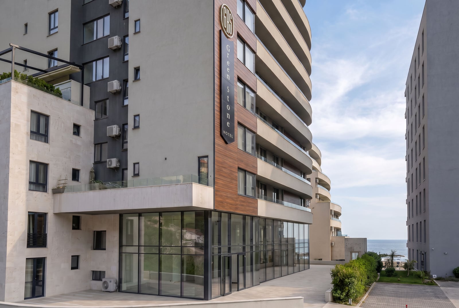 Современный фасад жилого комплекса Green Stone Hotel с панорамными окнами и балконами в Рафаиловичах, Черногория