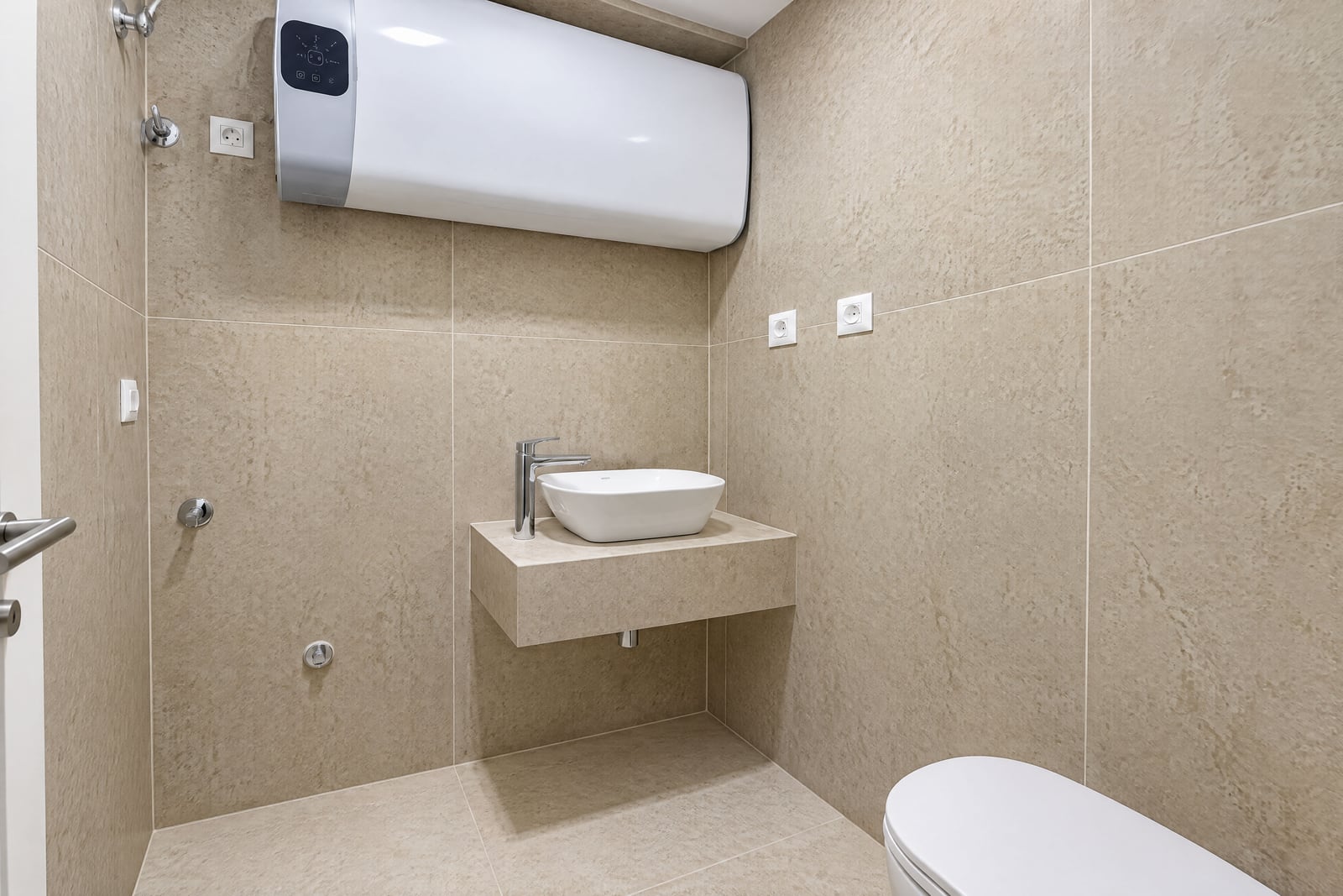 Salle de bain moderne avec chauffe-eau et lavabo dans un appartement à Bečići, Monténégro