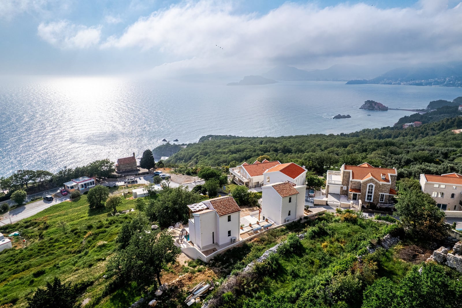 Vazdušni pogled na kompleks vila sa krovovima od crepa i panoramskim pogledom na more u Blizikučama, Crna Gora