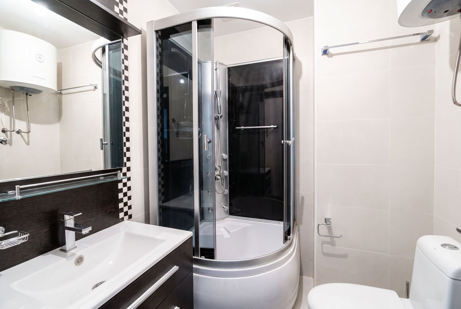 Modern bathroom with a shower cabin, sink, and water heater in an apartment in Petrovac, Montenegro