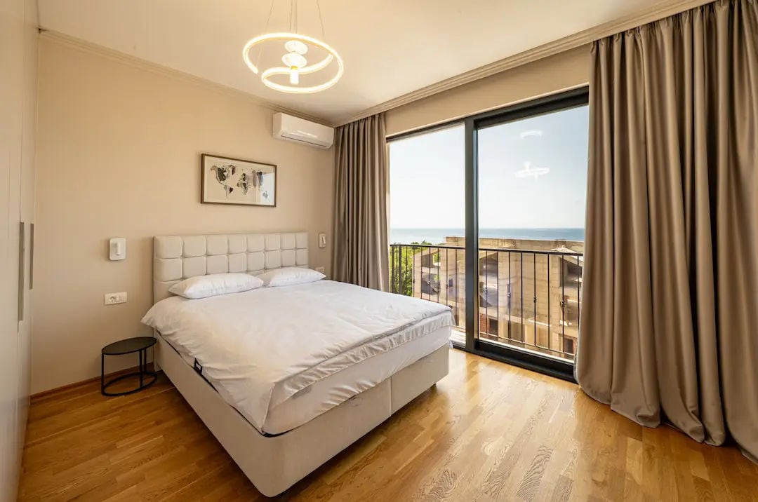 Chambre avec lit double et vue panoramique sur la mer dans une villa à Reževići, Monténégro. Intérieur moderne.