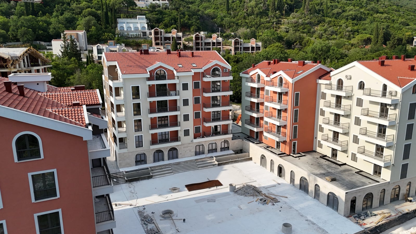 Pogled odozgo na moderne stambene zgrade sa crvenim krovovima i balkonima u gradu Tivtu, Crna Gora.